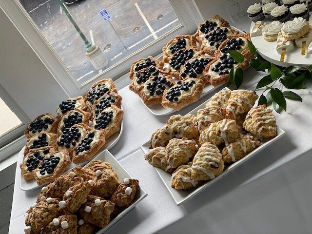 A table topped with plates of pastries and cupcakes.
