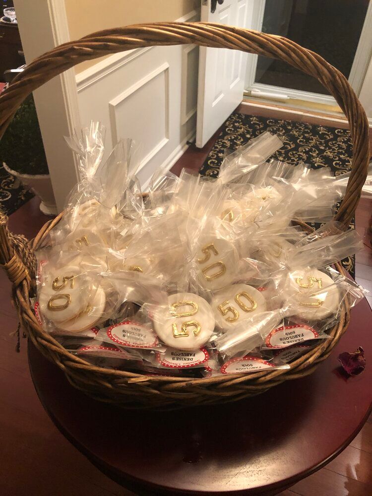 A basket filled with 50th anniversary cookies is sitting on a table.