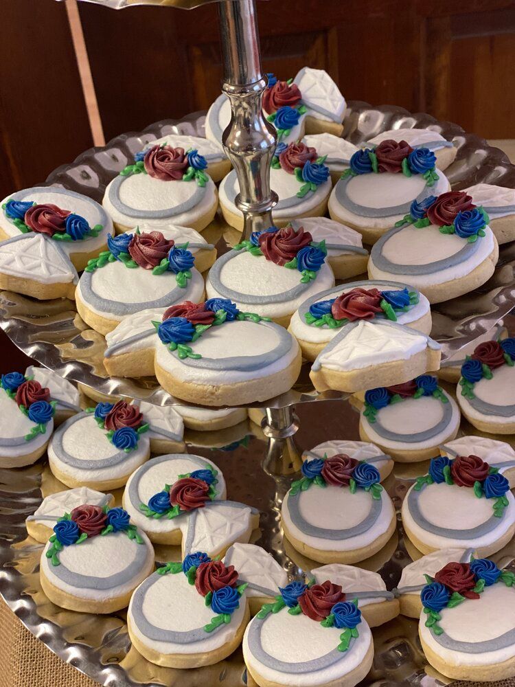 A glass plate topped with a bunch of cookies decorated with flowers.