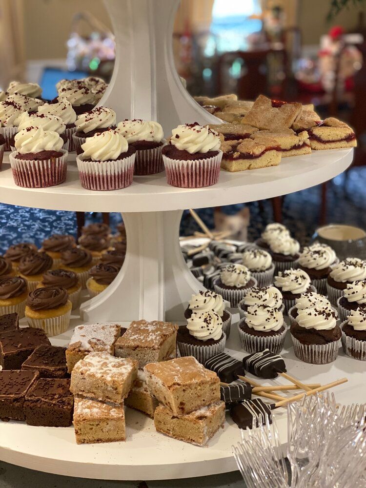 A display of cupcakes , brownies , and other desserts on a table.