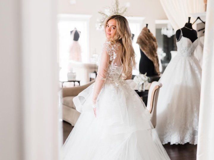 A woman is trying on a wedding dress in a bridal shop.