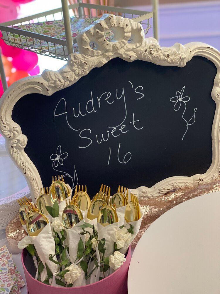 A chalkboard with the words `` audrey 's sweet 16 '' written on it