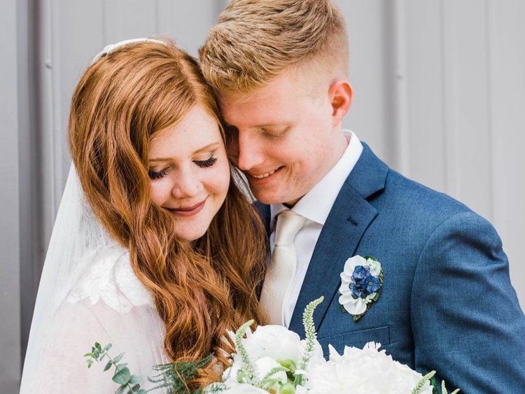 A bride and groom are posing for a picture on their wedding day.