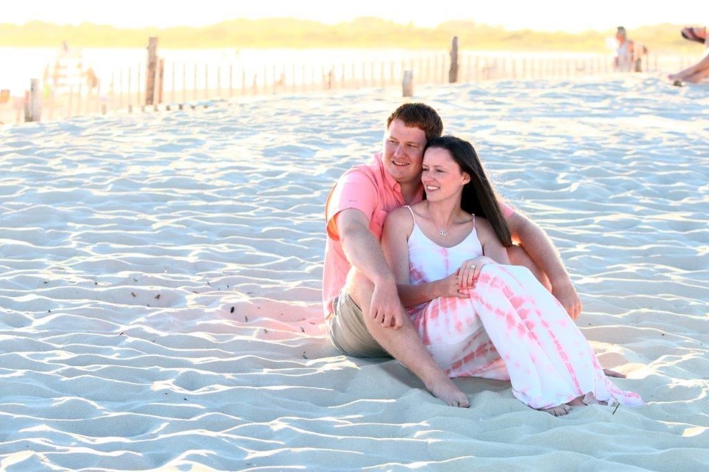 A man and a woman are sitting on the beach.