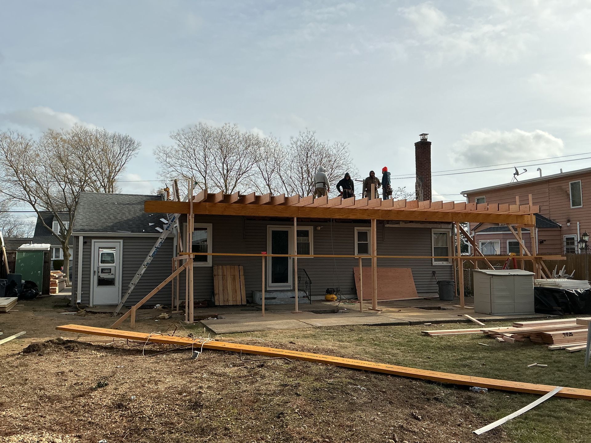 House under construction with workers on the roof and scaffolding in front