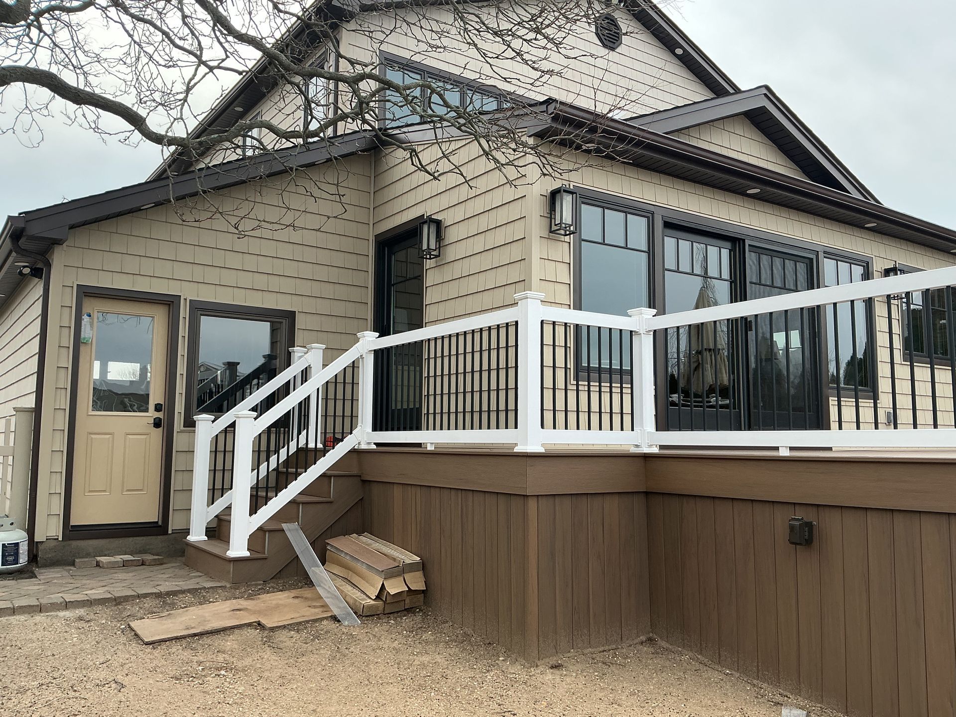 House exterior with front porch, white railing, and beige siding on a raised deck