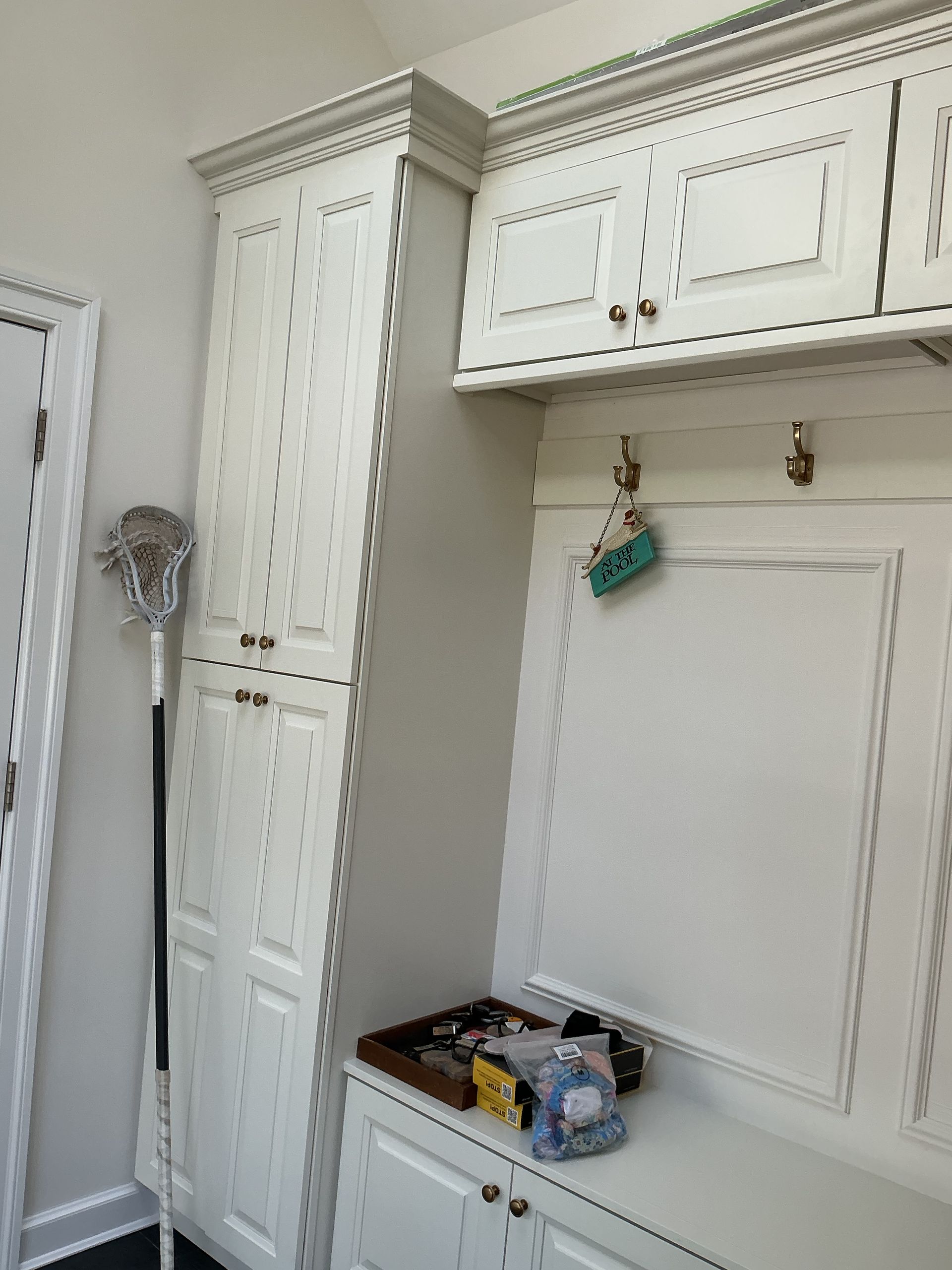 White built-in kitchen cabinets and shelving with a few items on the counter in a bright room
