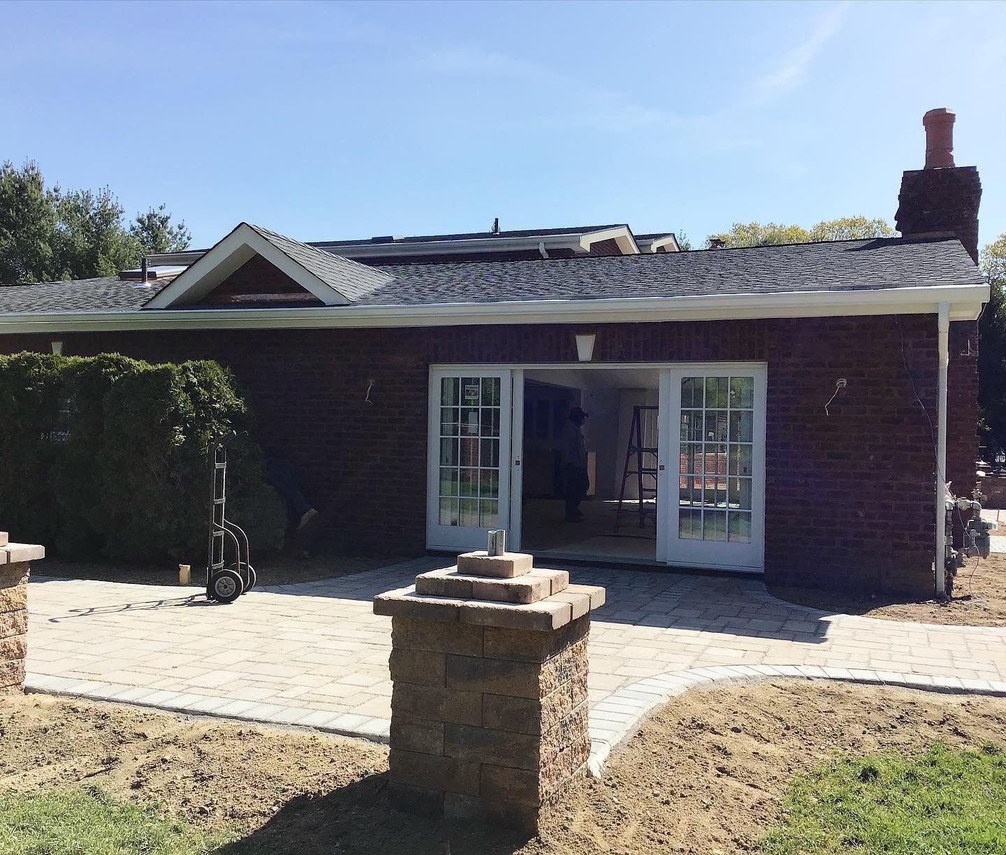 Brick building with French doors and patio, two brick pillars in the foreground.