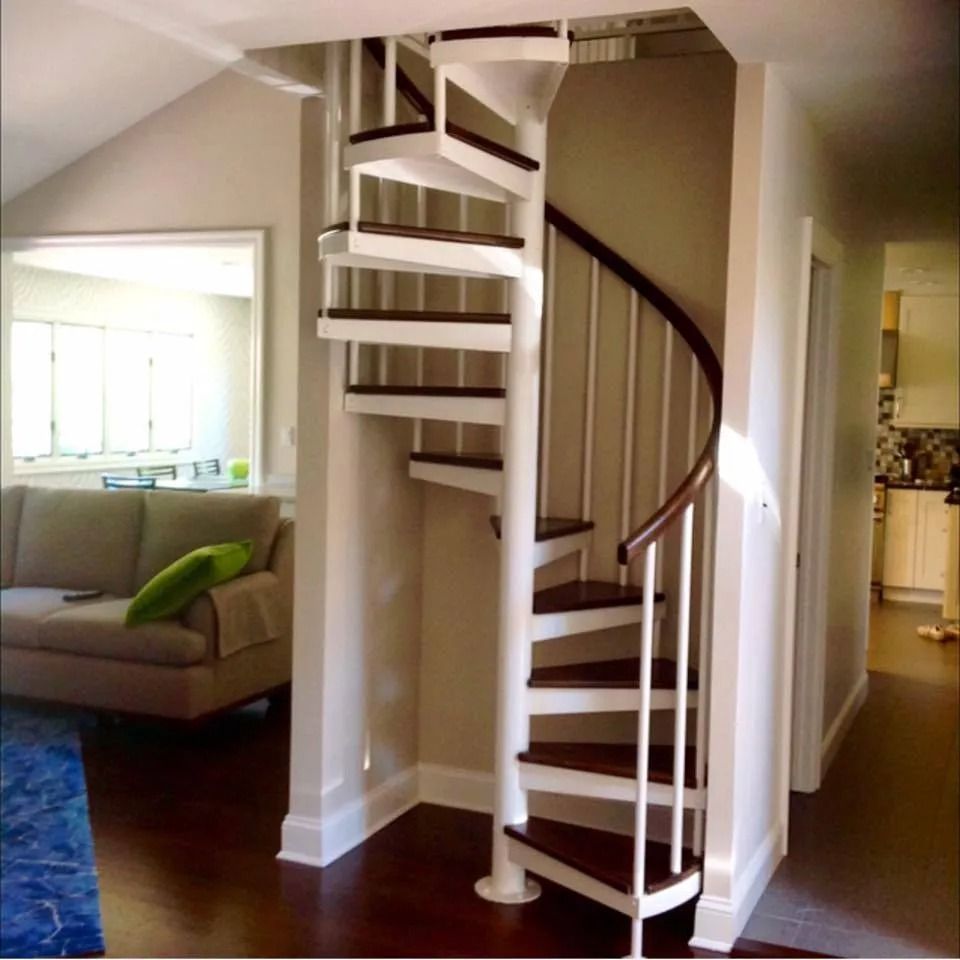 Spiral staircase with dark wood treads, white risers, and a brown handrail.