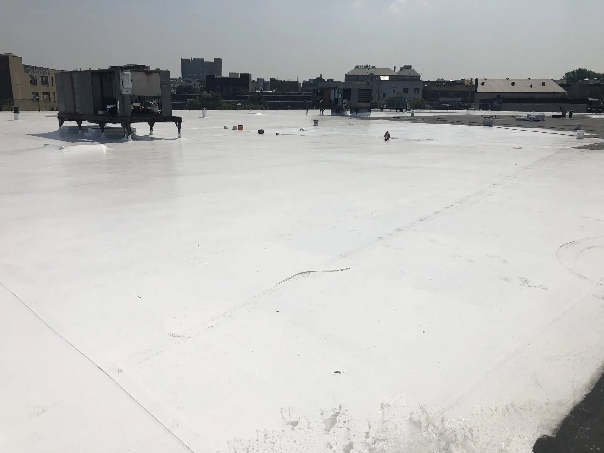 White rooftop with city buildings in background on a sunny day.