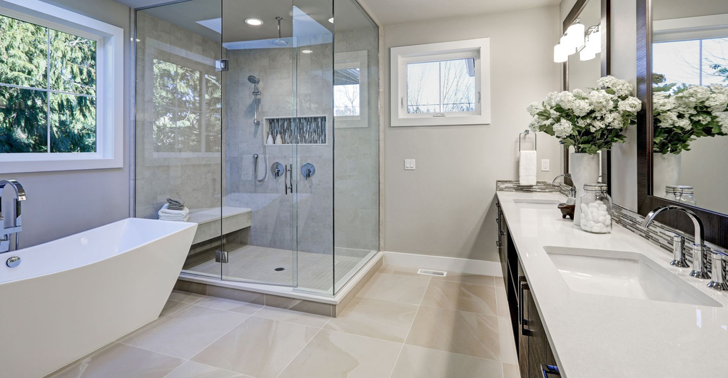 Bright modern bathroom with freestanding tub, glass shower, and double vanity with flowers