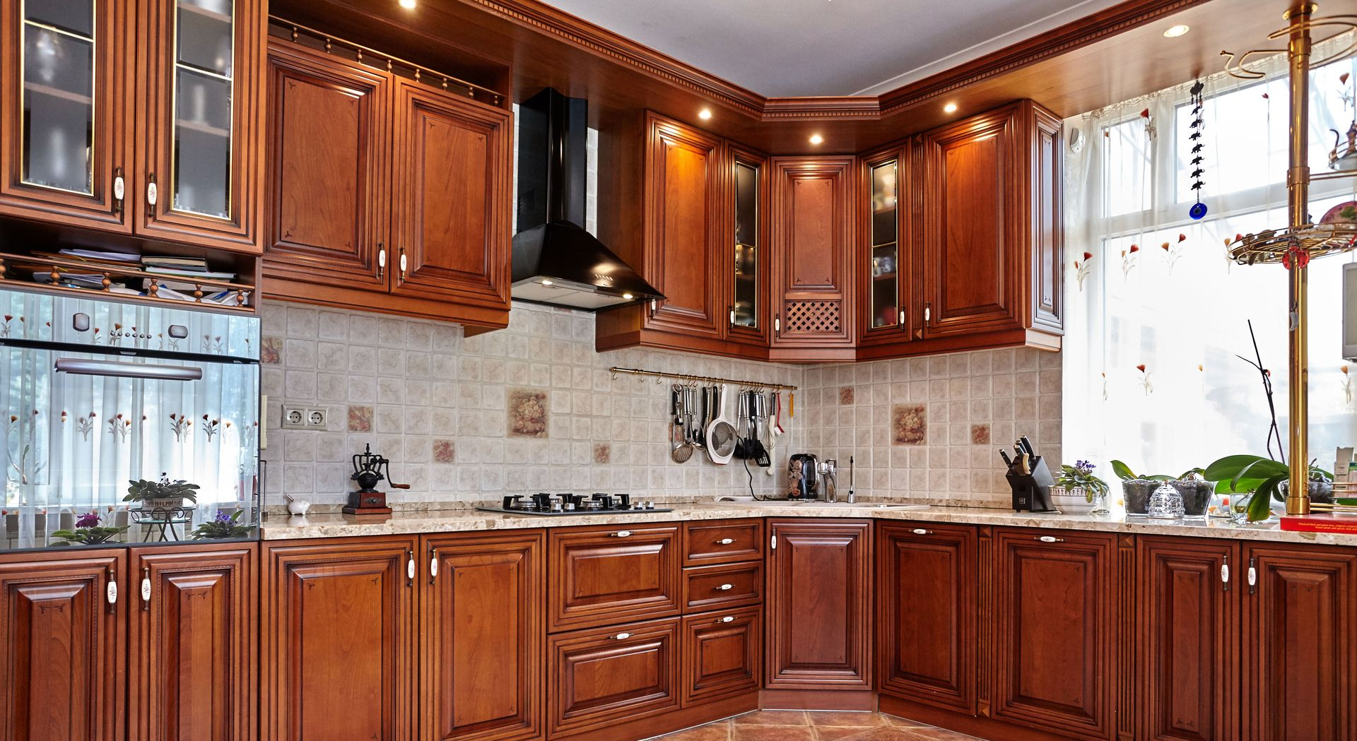Bright kitchen with wooden cabinets, tiled backsplash, and sunlight through a window