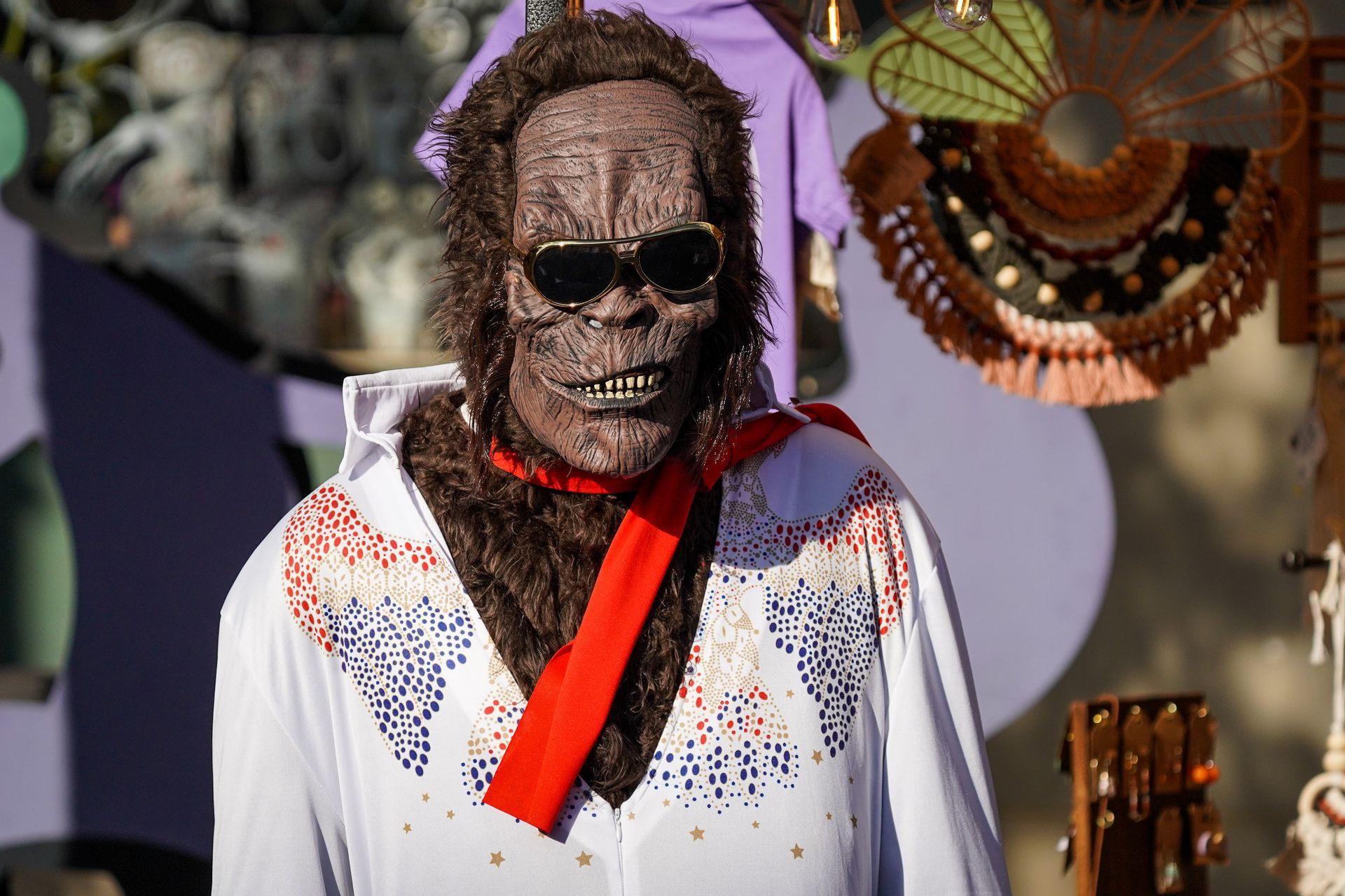 a man dressed as elvis presley is wearing sunglasses and a scarf around his neck