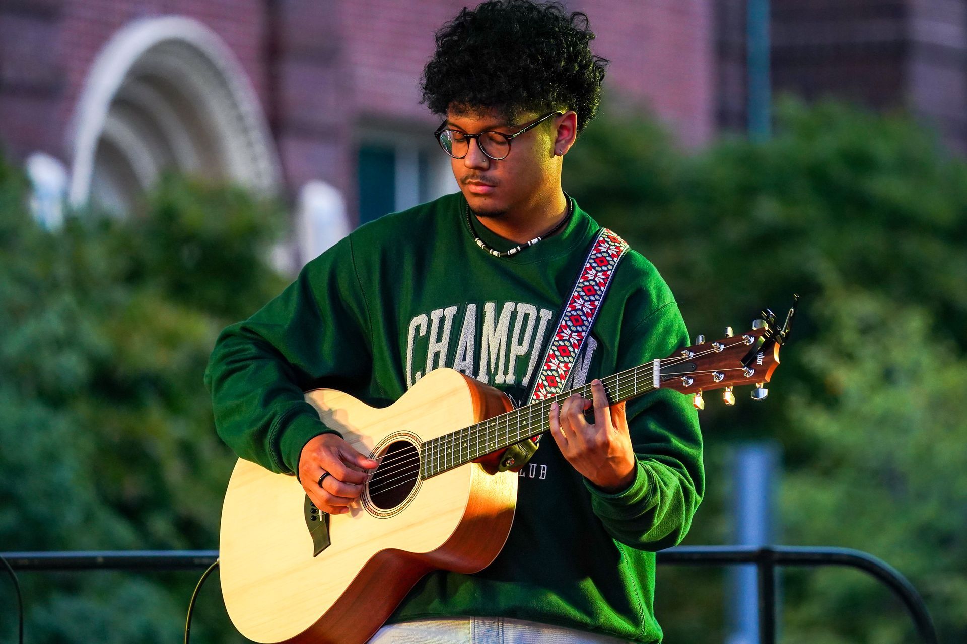 man with green shirt playing a guitar