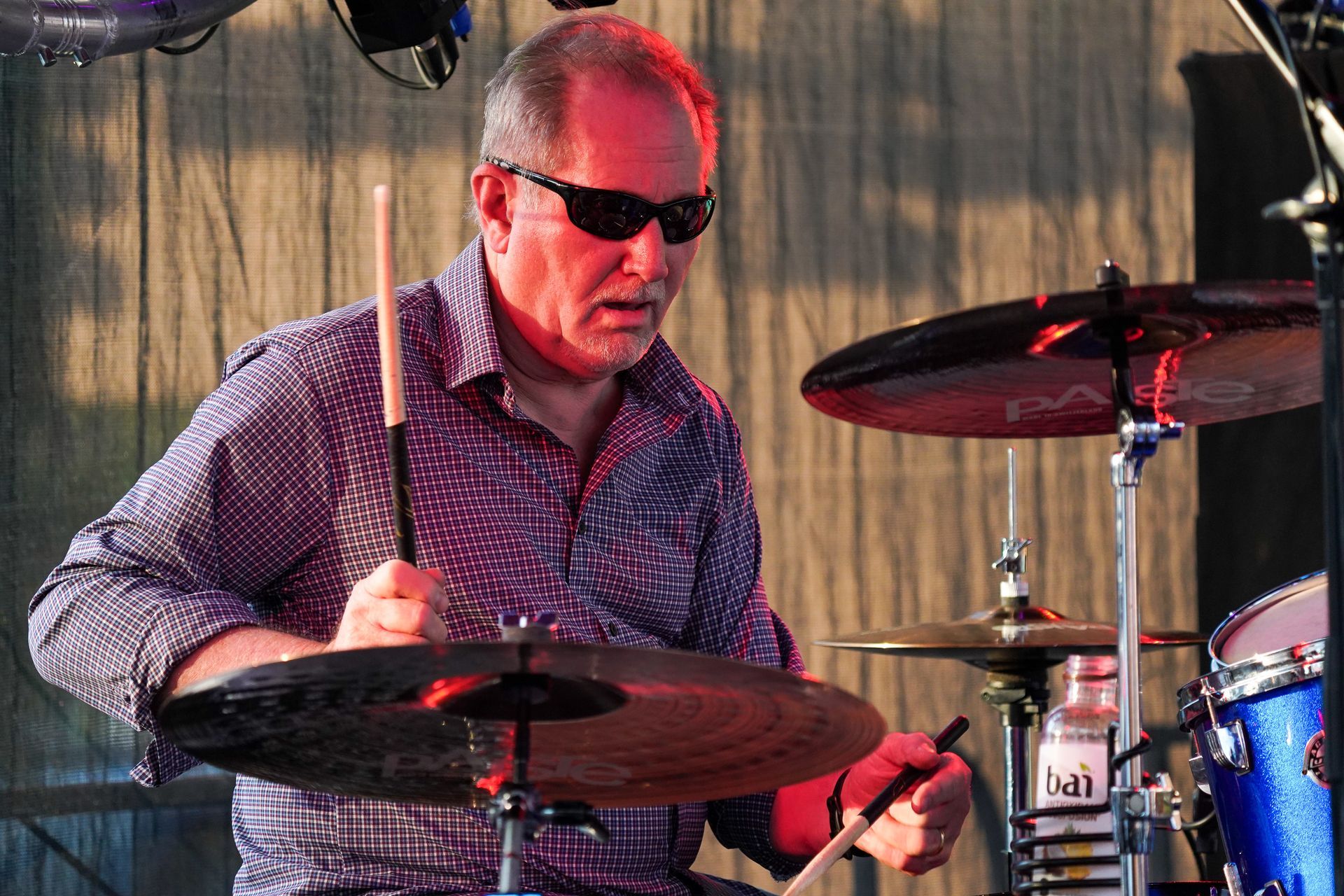 man with glasses playing drums