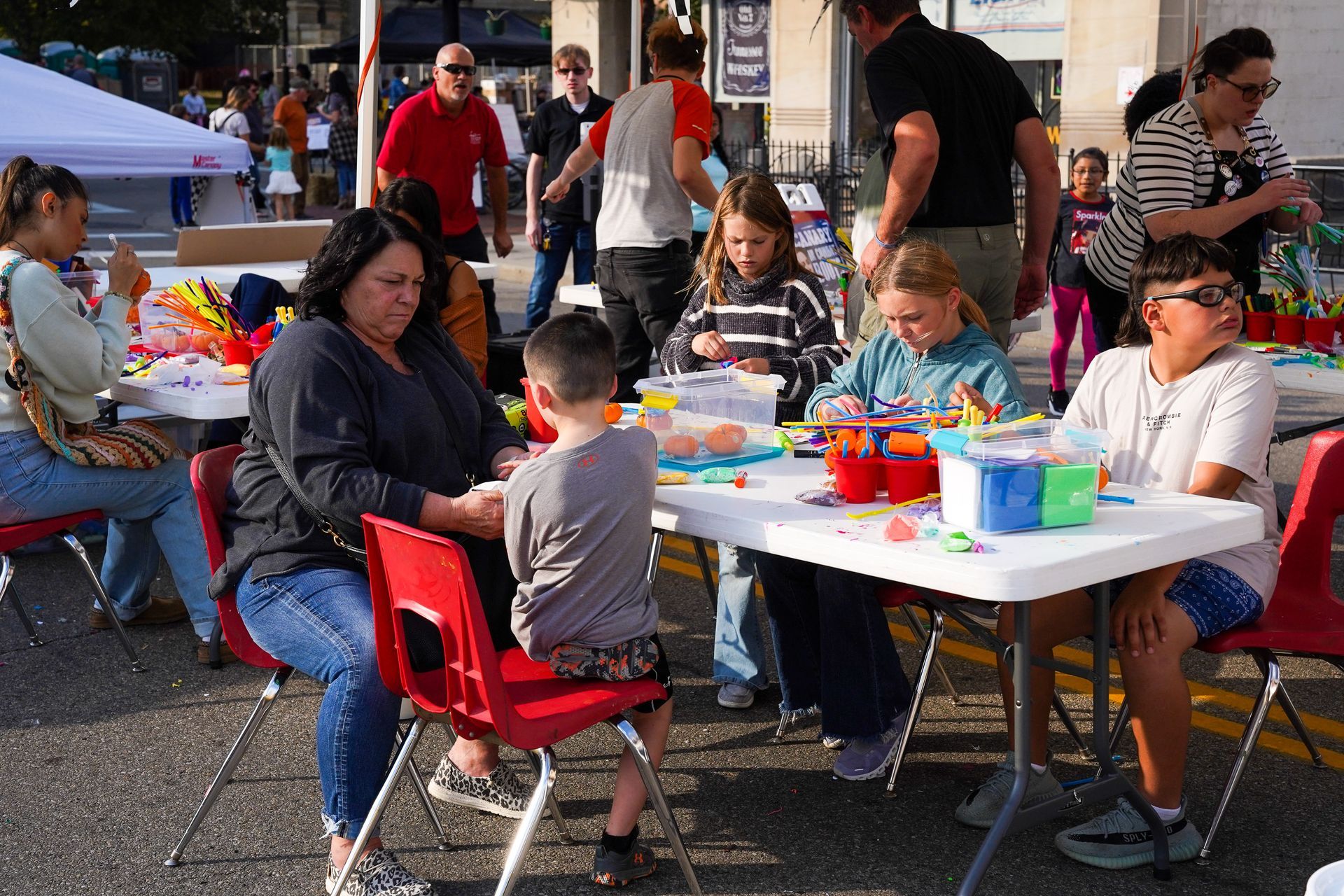 a group of people are sitting around a table playing with toys