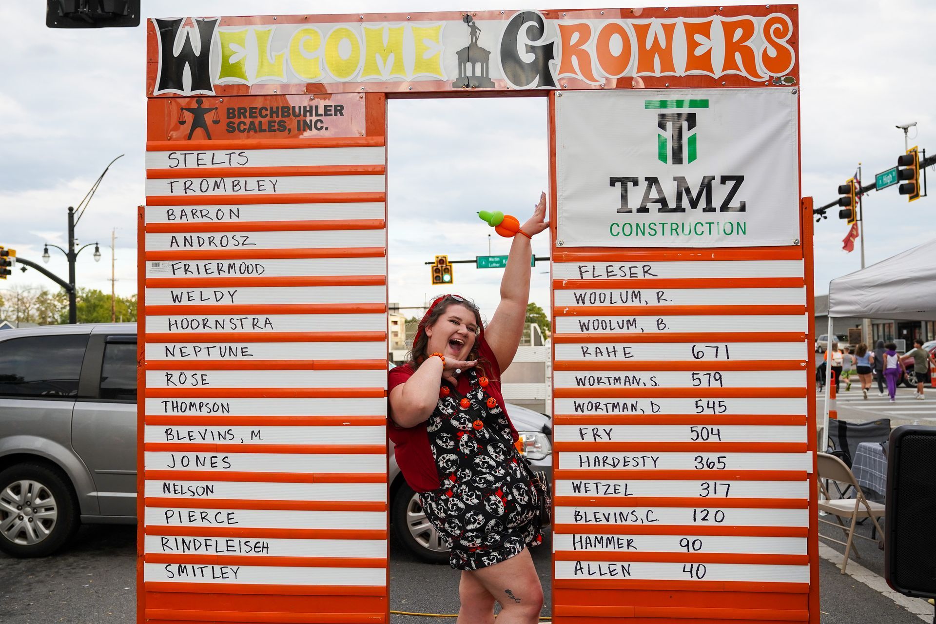 a woman is standing in front of a sign that says welcome growers