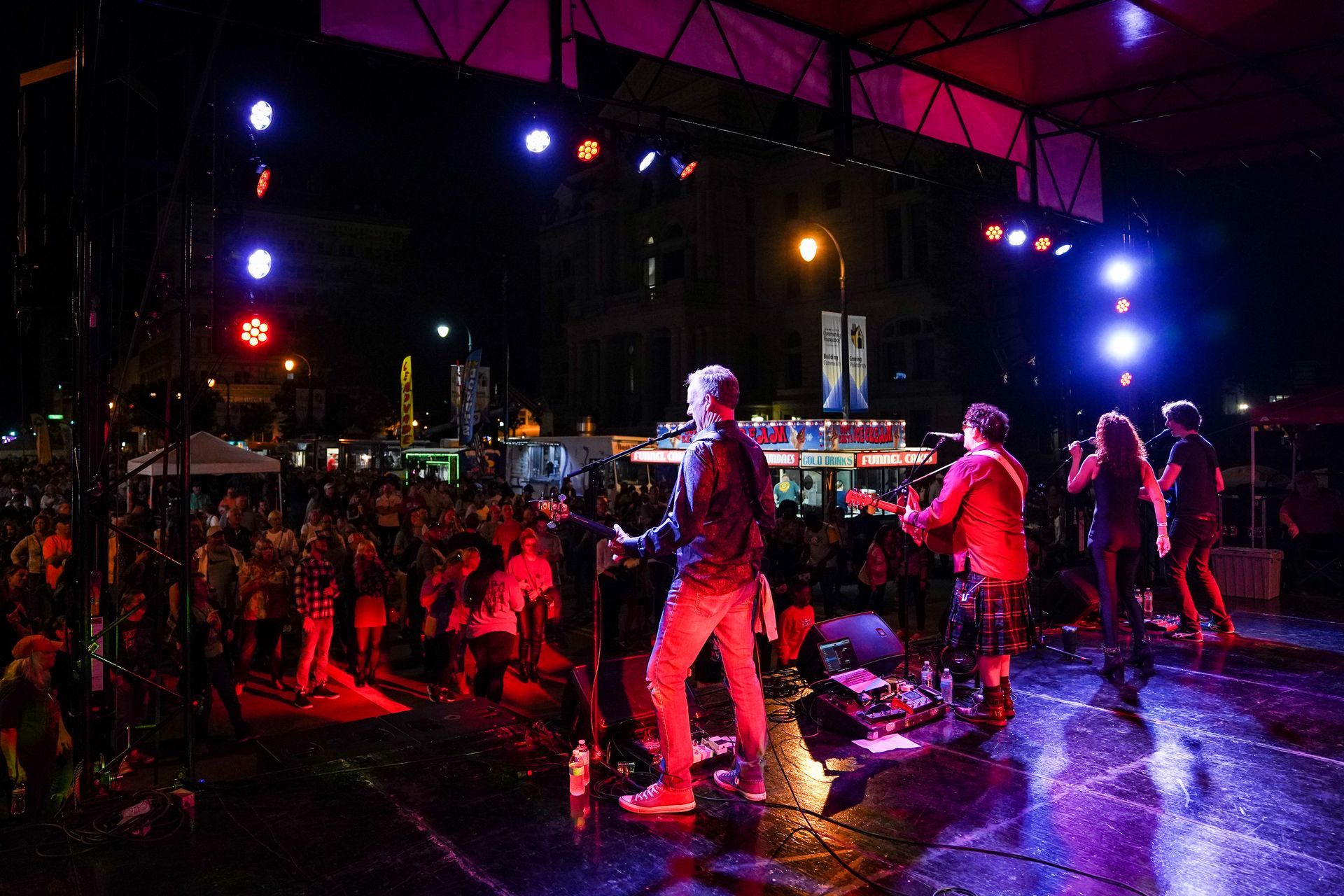 a group of people are standing on a stage in front of a crowd