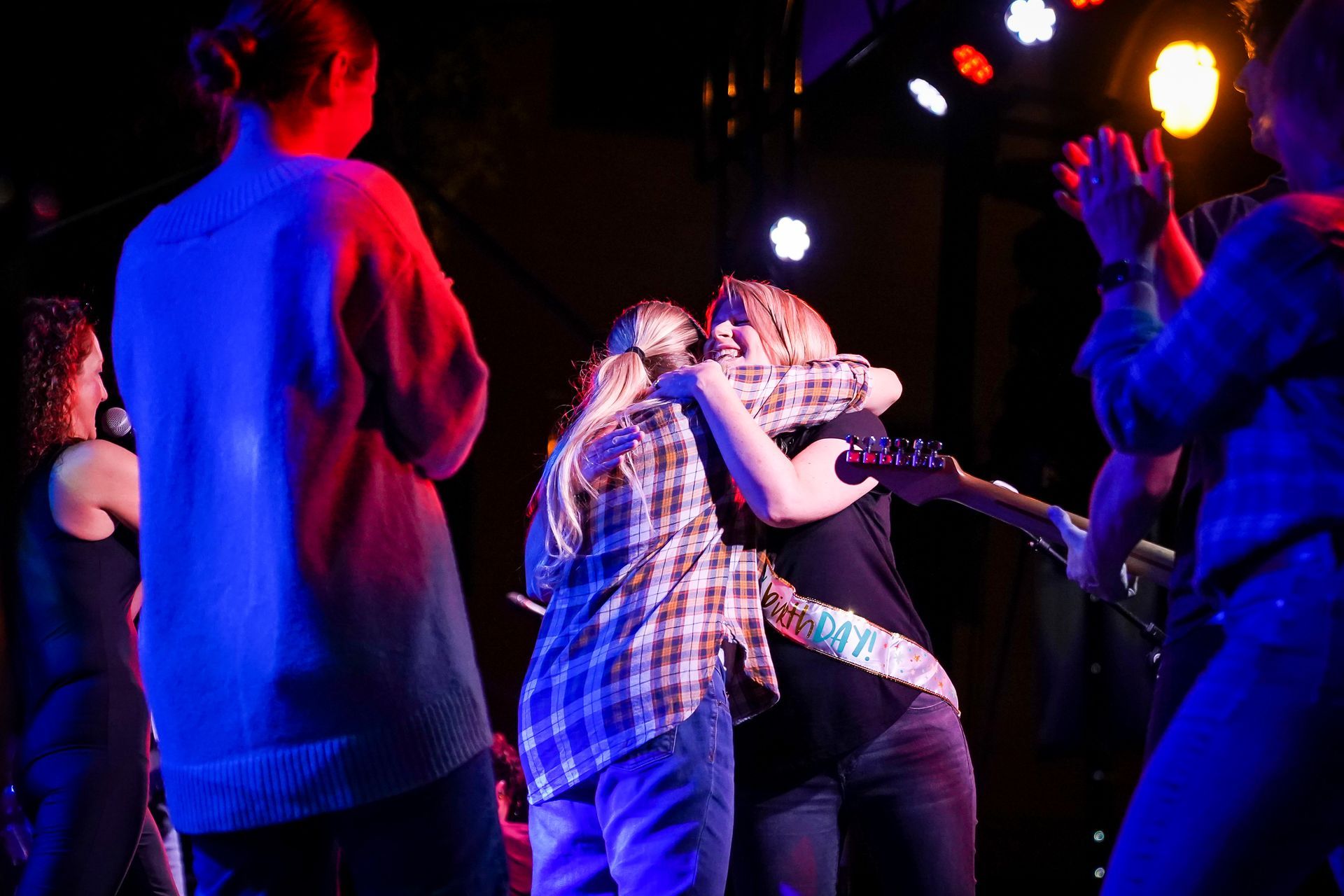 a group of people are dancing in a dark room with blue lights