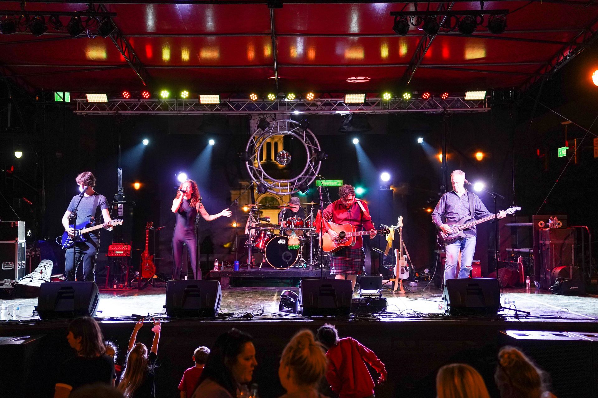 a group of people are watching a band on stage