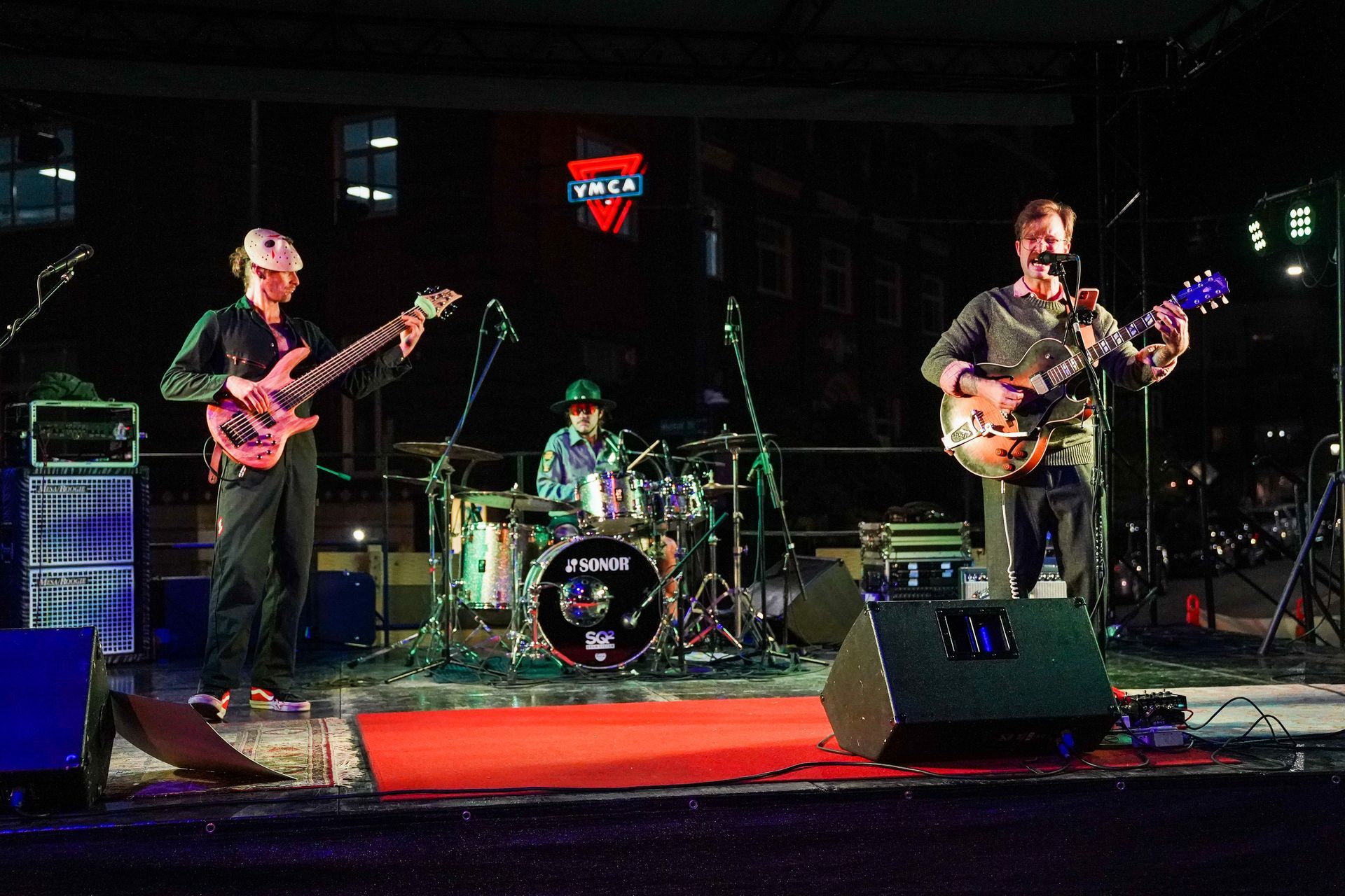 a group of people are playing guitars and drums on a stage