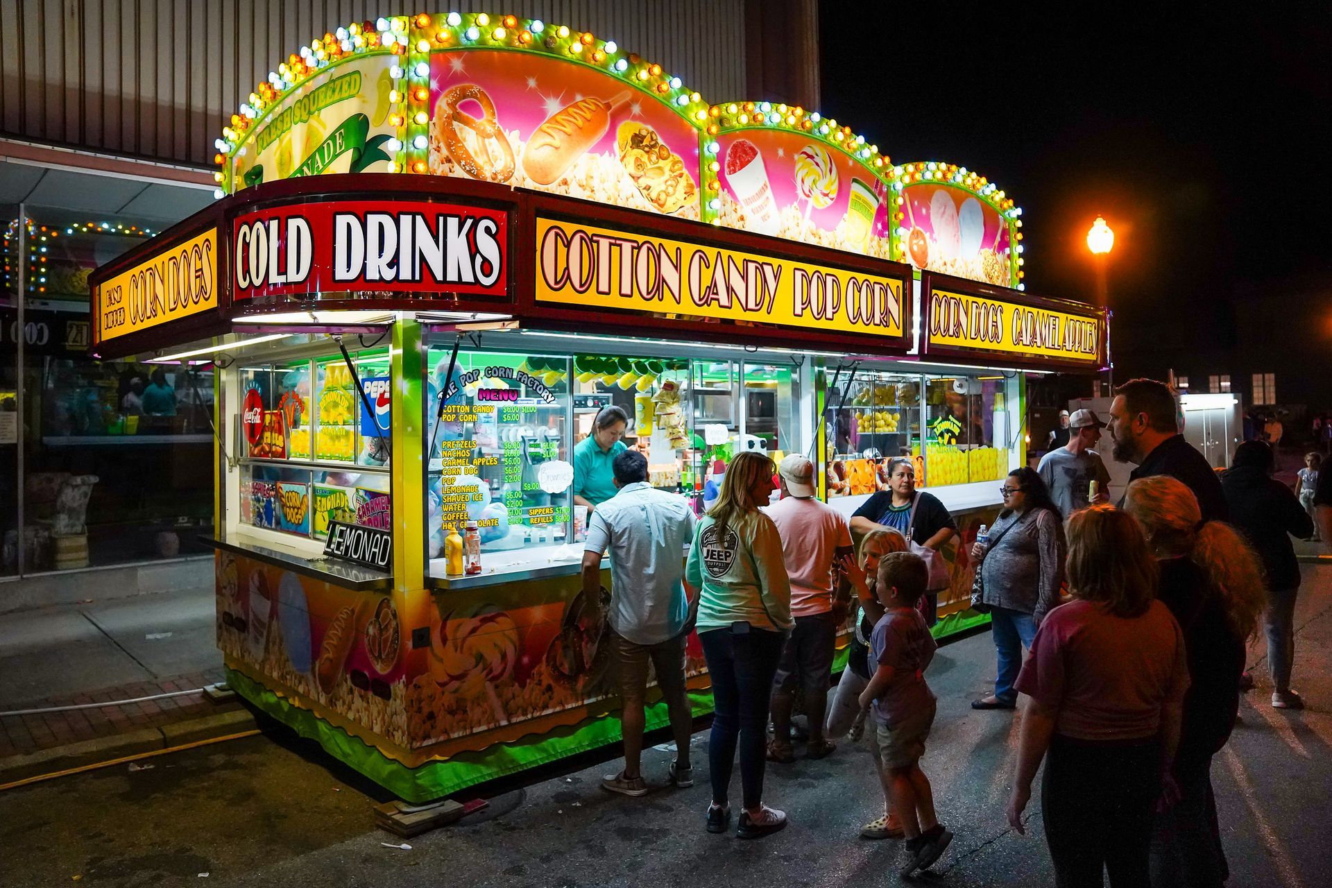 a group of people standing in front of a cold drinks stand