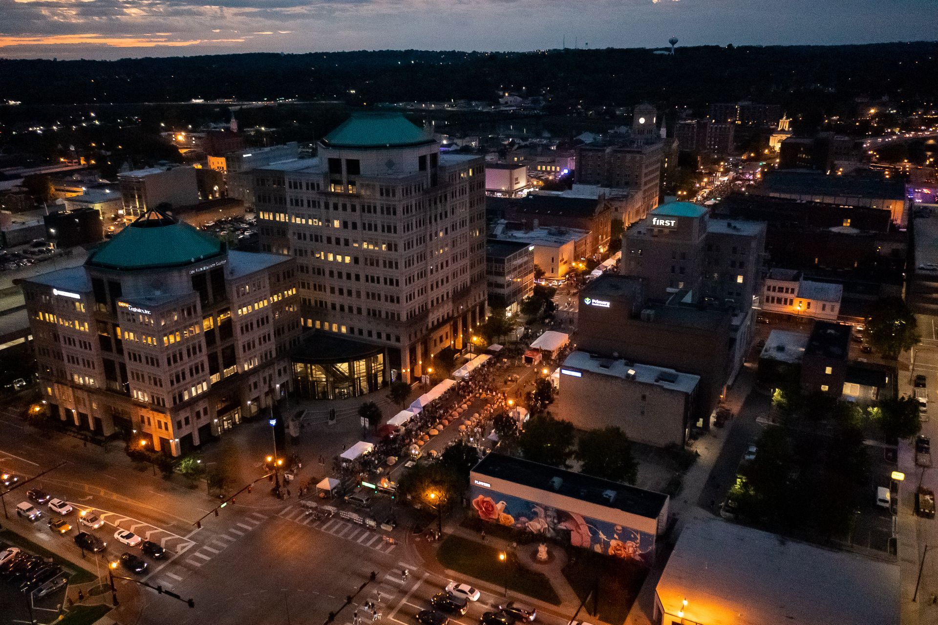 an aerial view of a city at night with lots of buildings