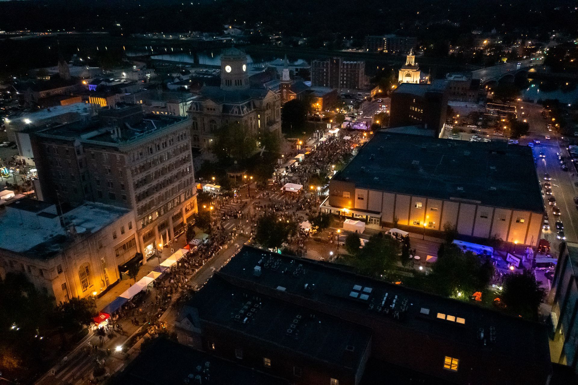 an aerial view of a city at night with lots of lights on the buildings