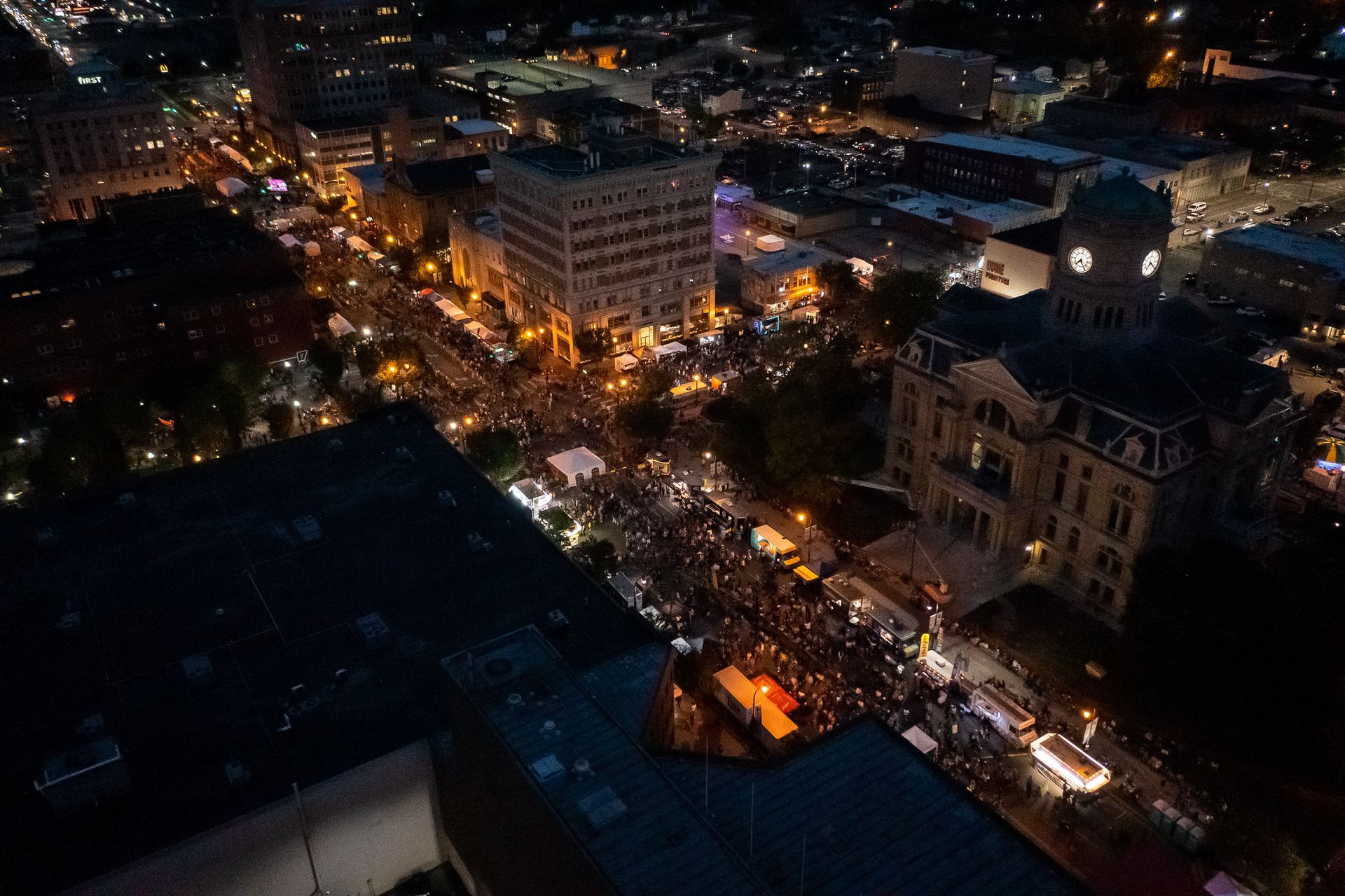 an aerial view of a city at night with lots of lights and buildings