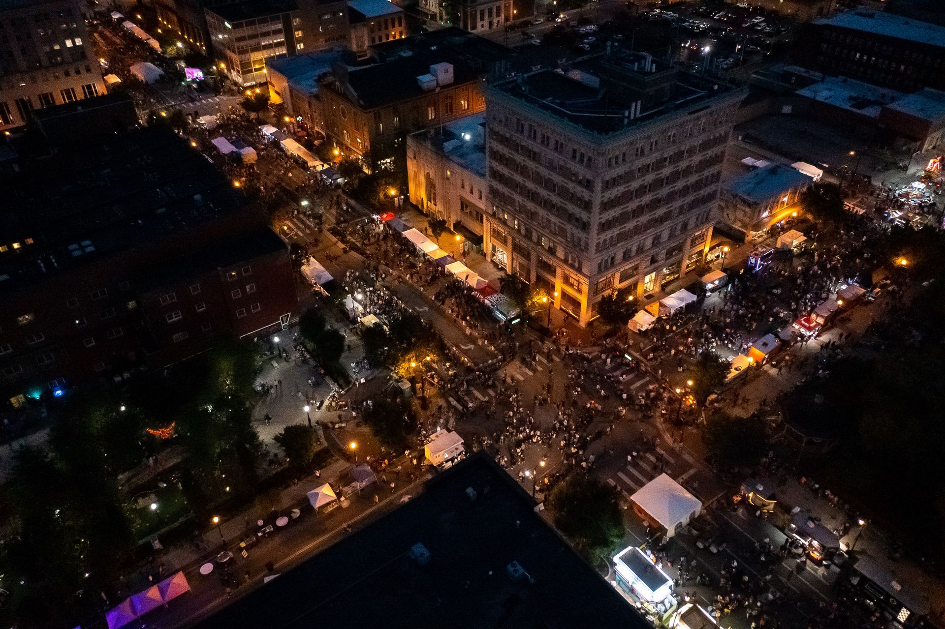 an aerial view of a city at night with lots of lights and buildings