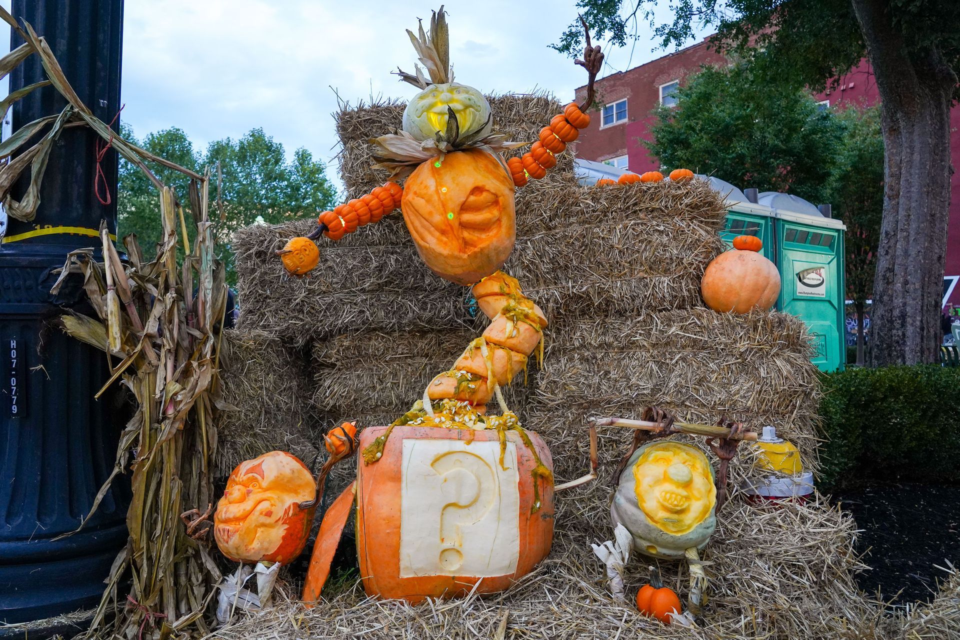 a scarecrow made out of pumpkins is sitting on a pile of hay