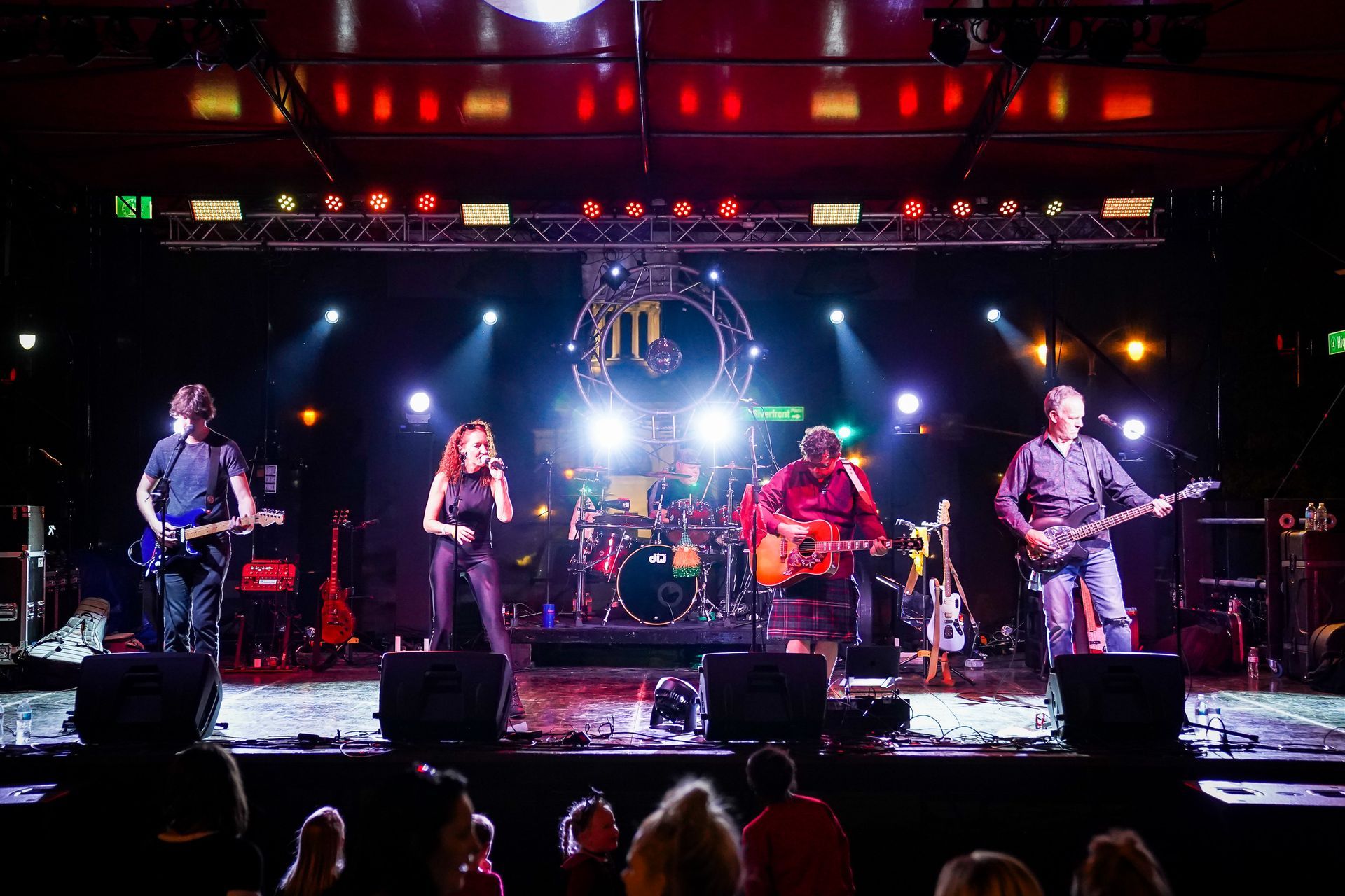 a group of people are playing instruments on a stage in front of a crowd