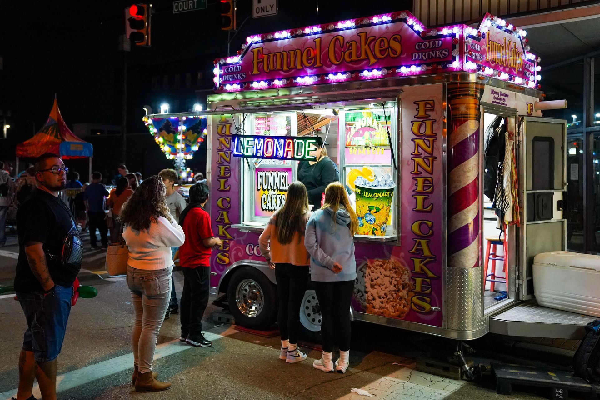 a group of people are standing in front of a food truck