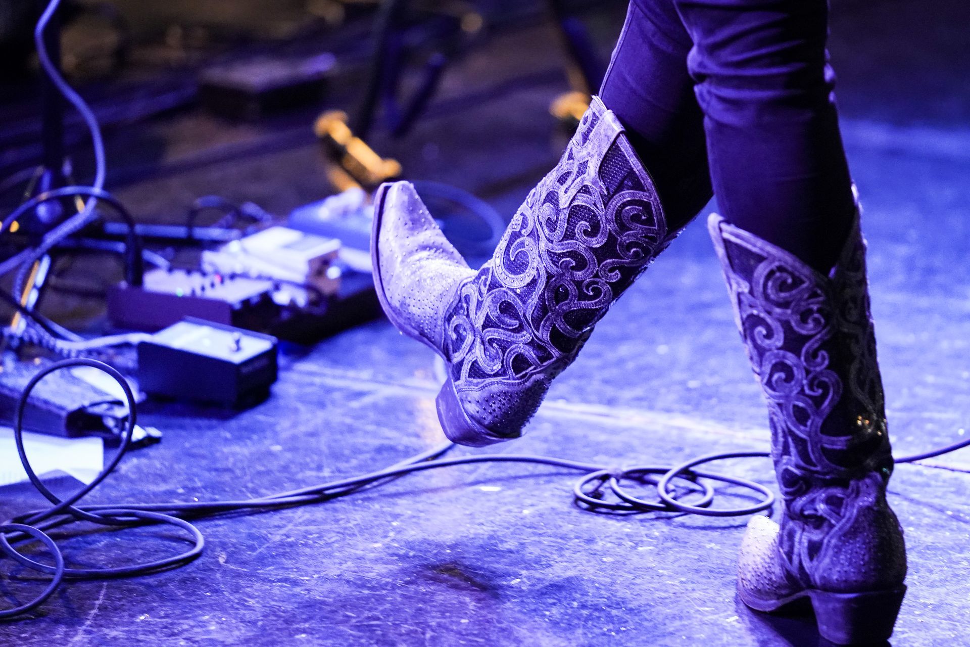 a person wearing cowboy boots is standing on a stage