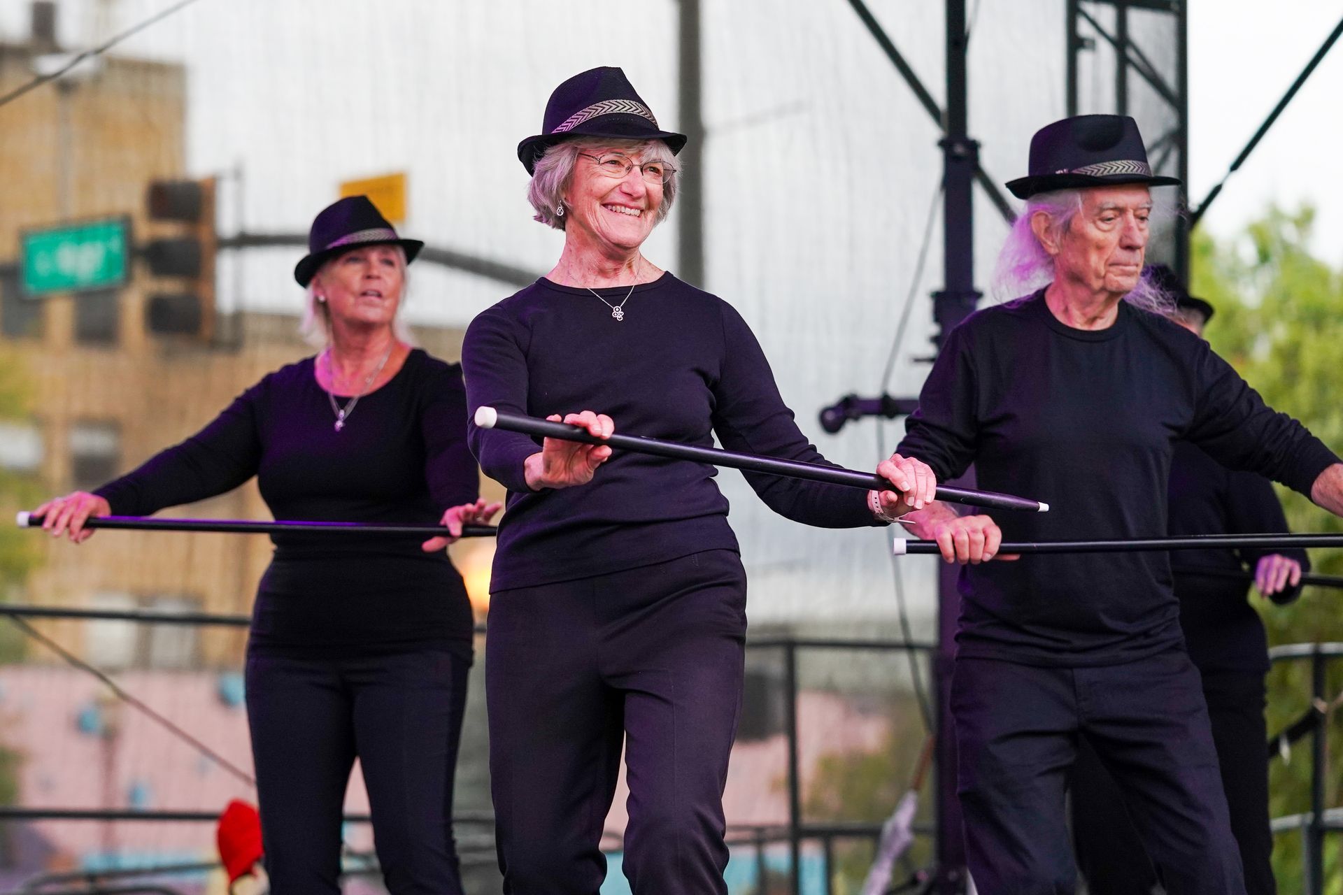 a group of older women are dancing with canes on a stage 