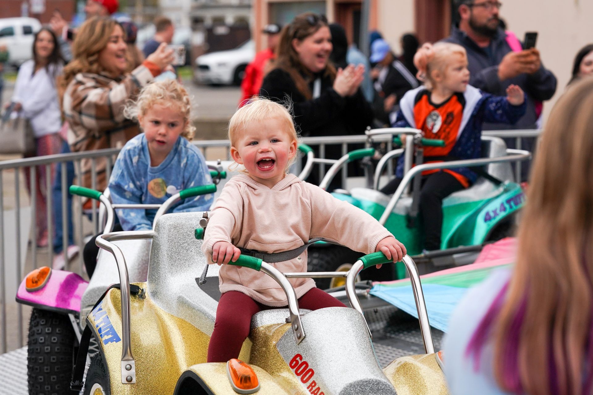 a group of children are riding go karts at a carnival 