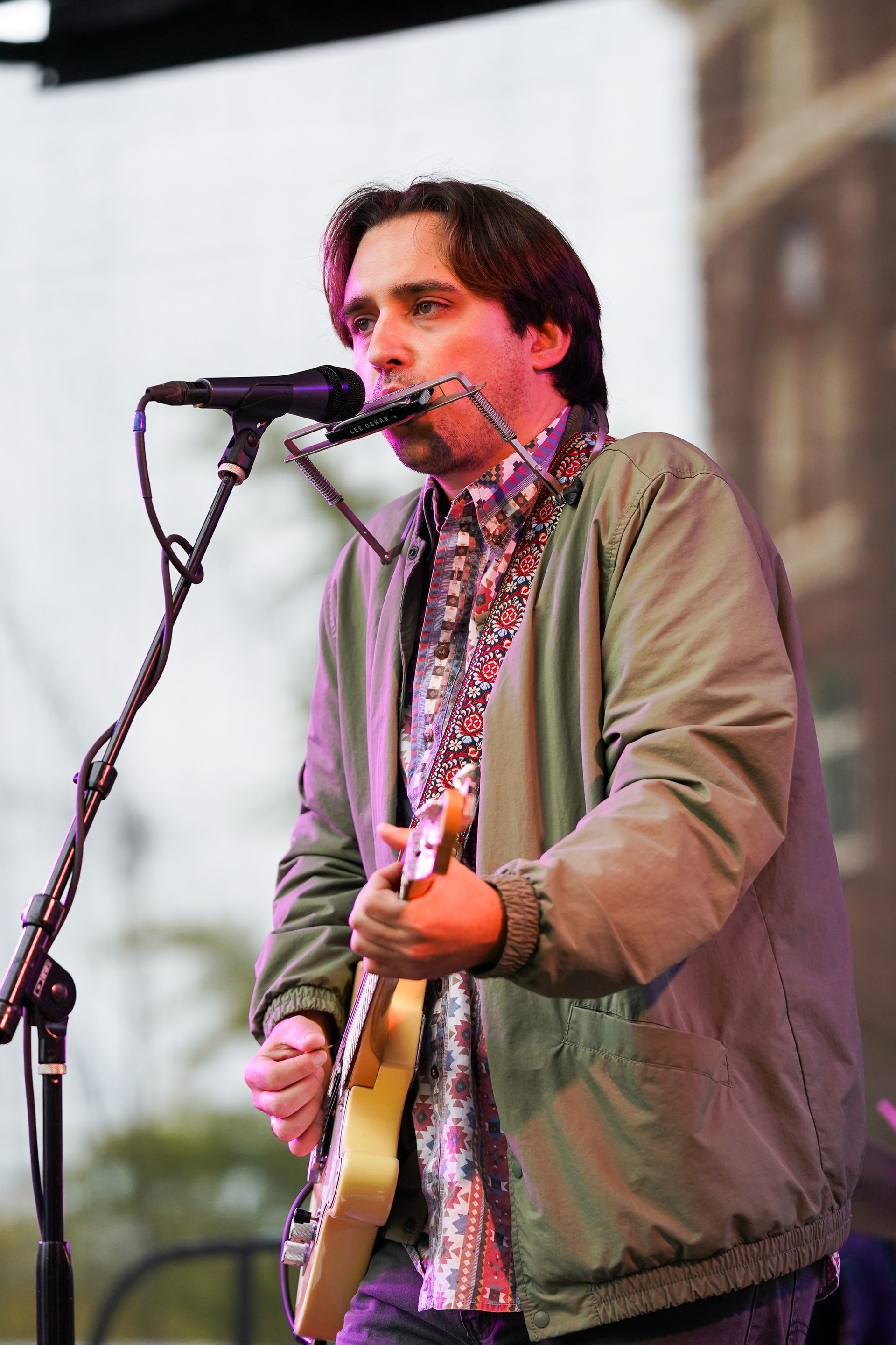 a man is singing into a microphone while playing a guitar