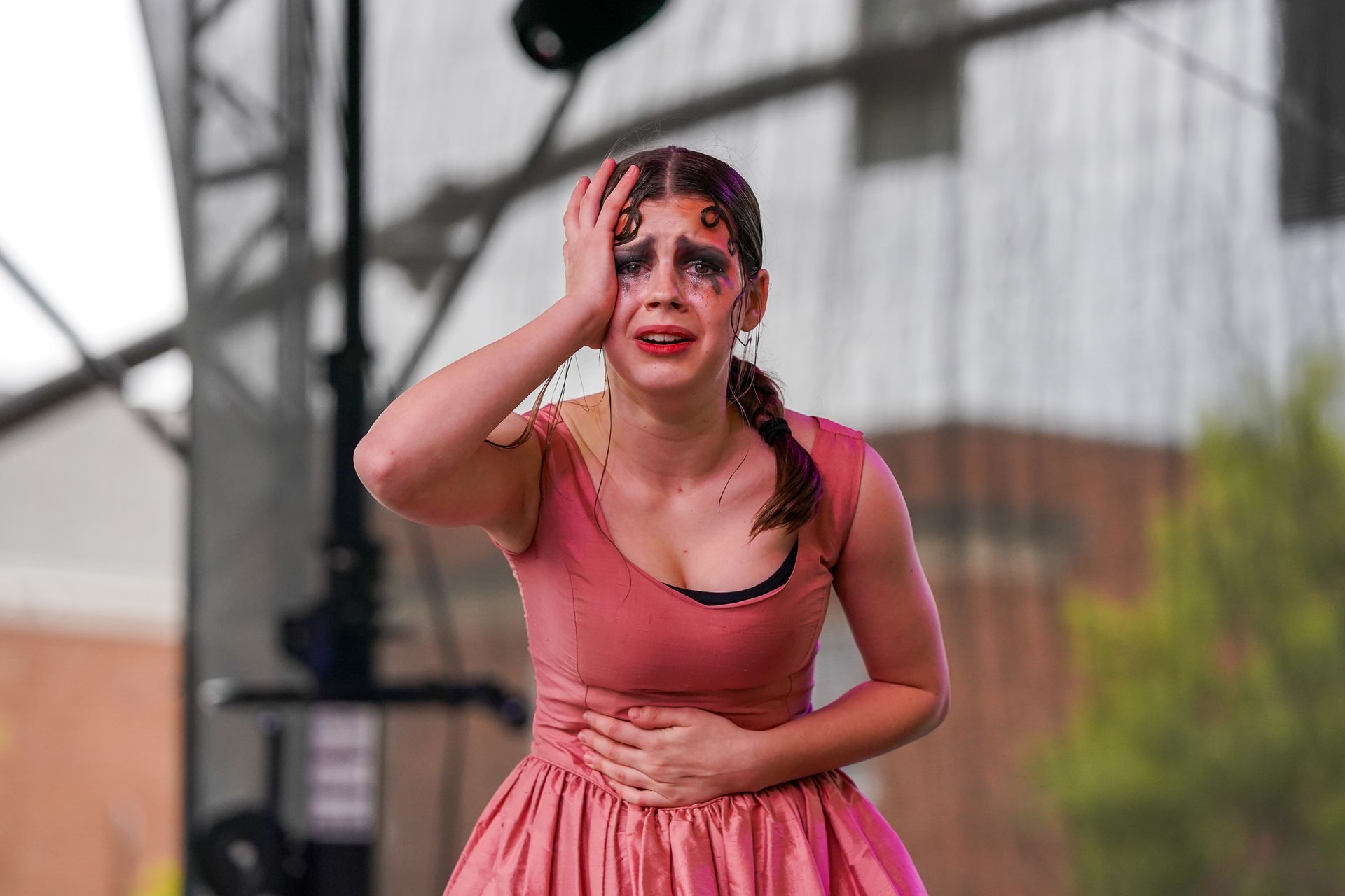 a woman in a pink dress is crying and holding her head