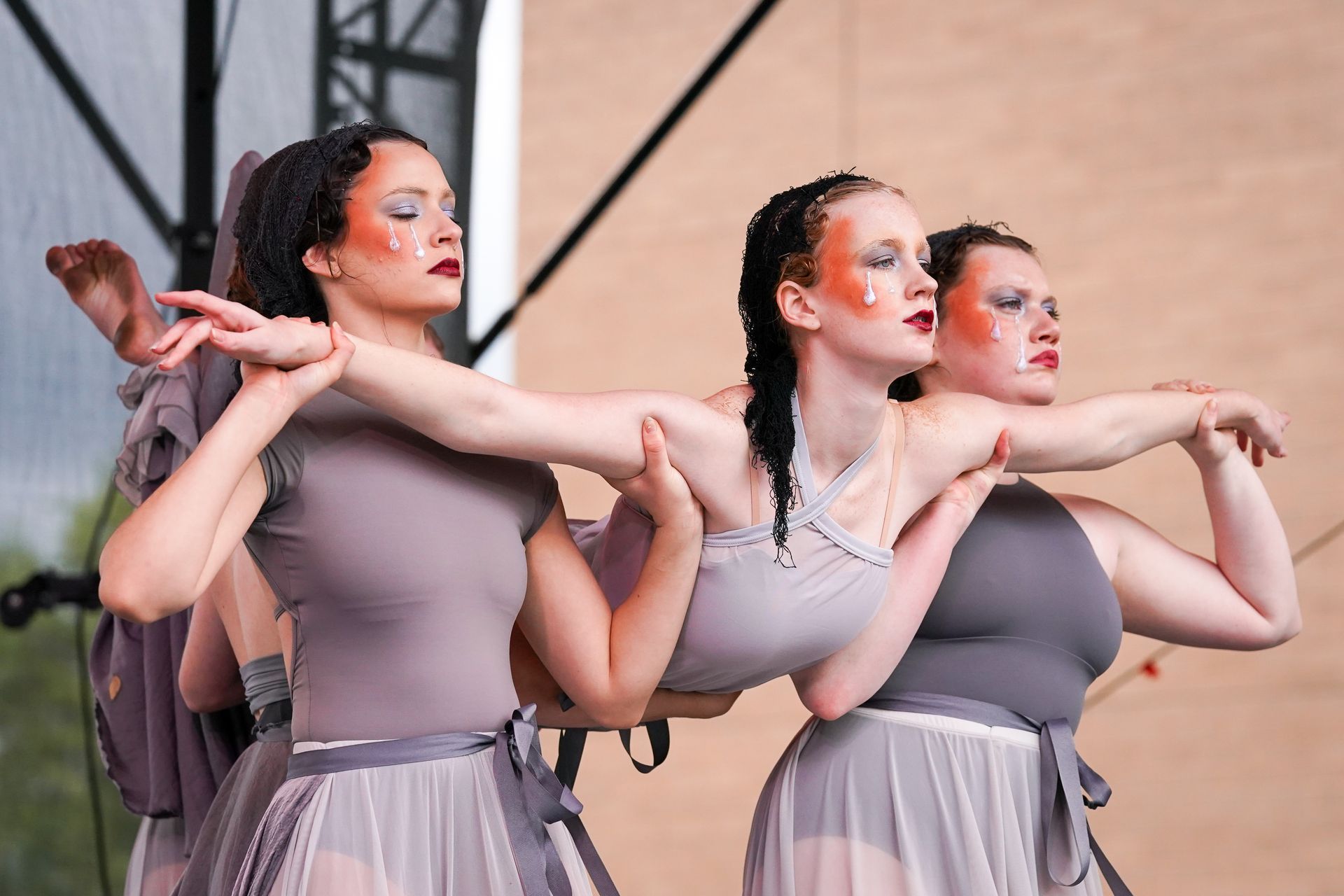 a group of three women are dancing together on a stage