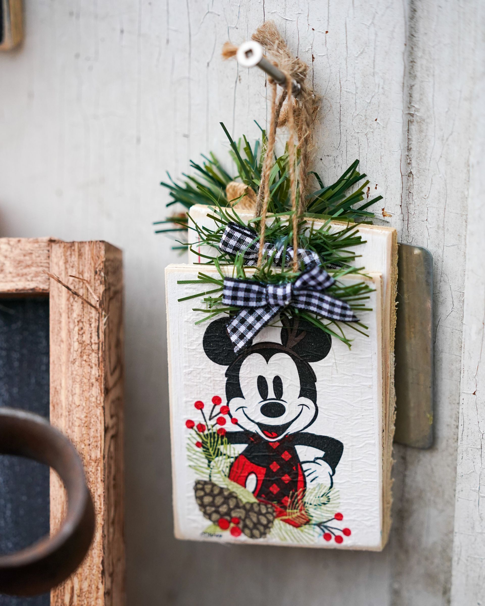 a mickey mouse christmas ornament is hanging on a wall