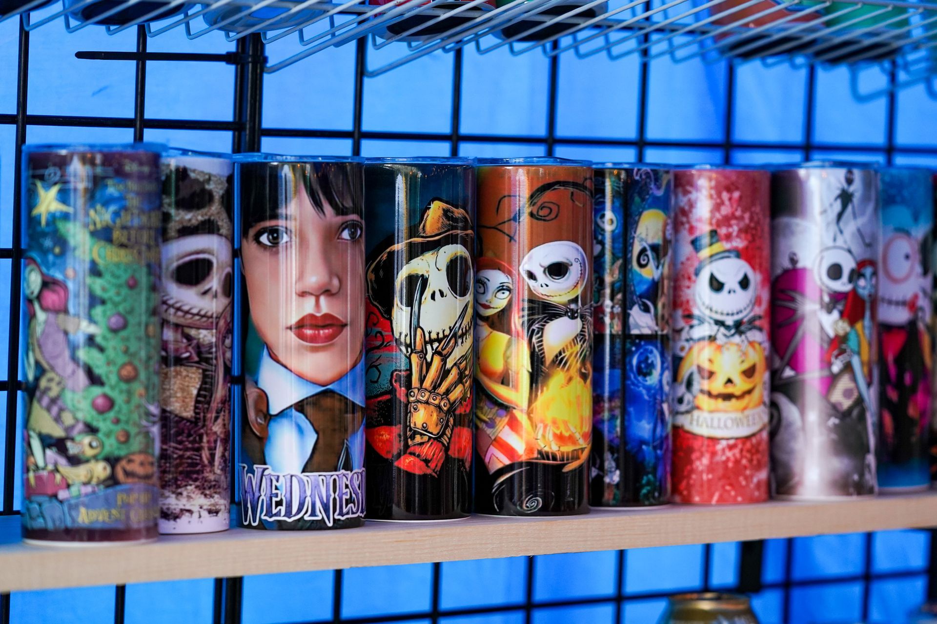 a row of tumblers with different designs on them are sitting on a shelf