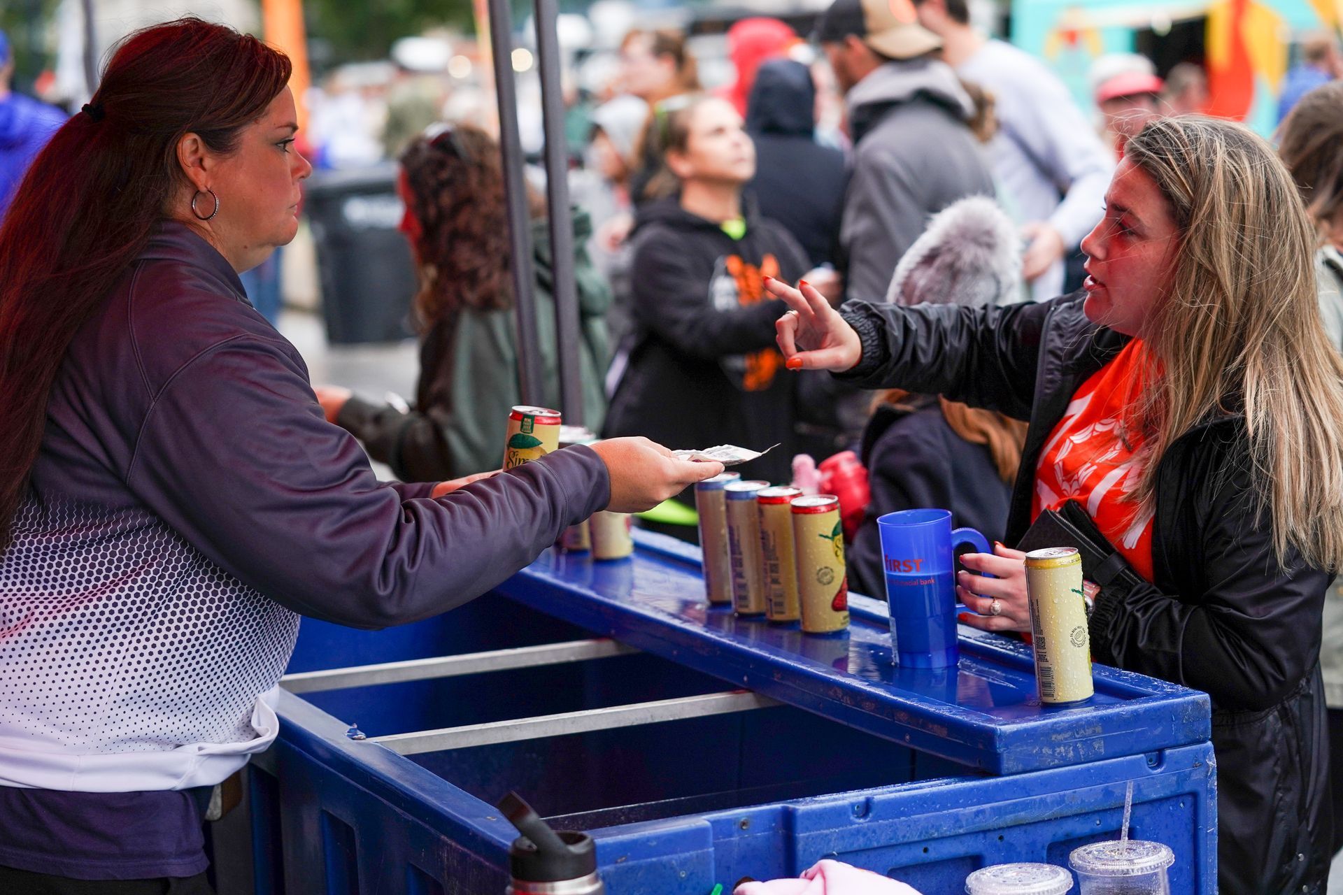 two women are standing at a table talking to each other
