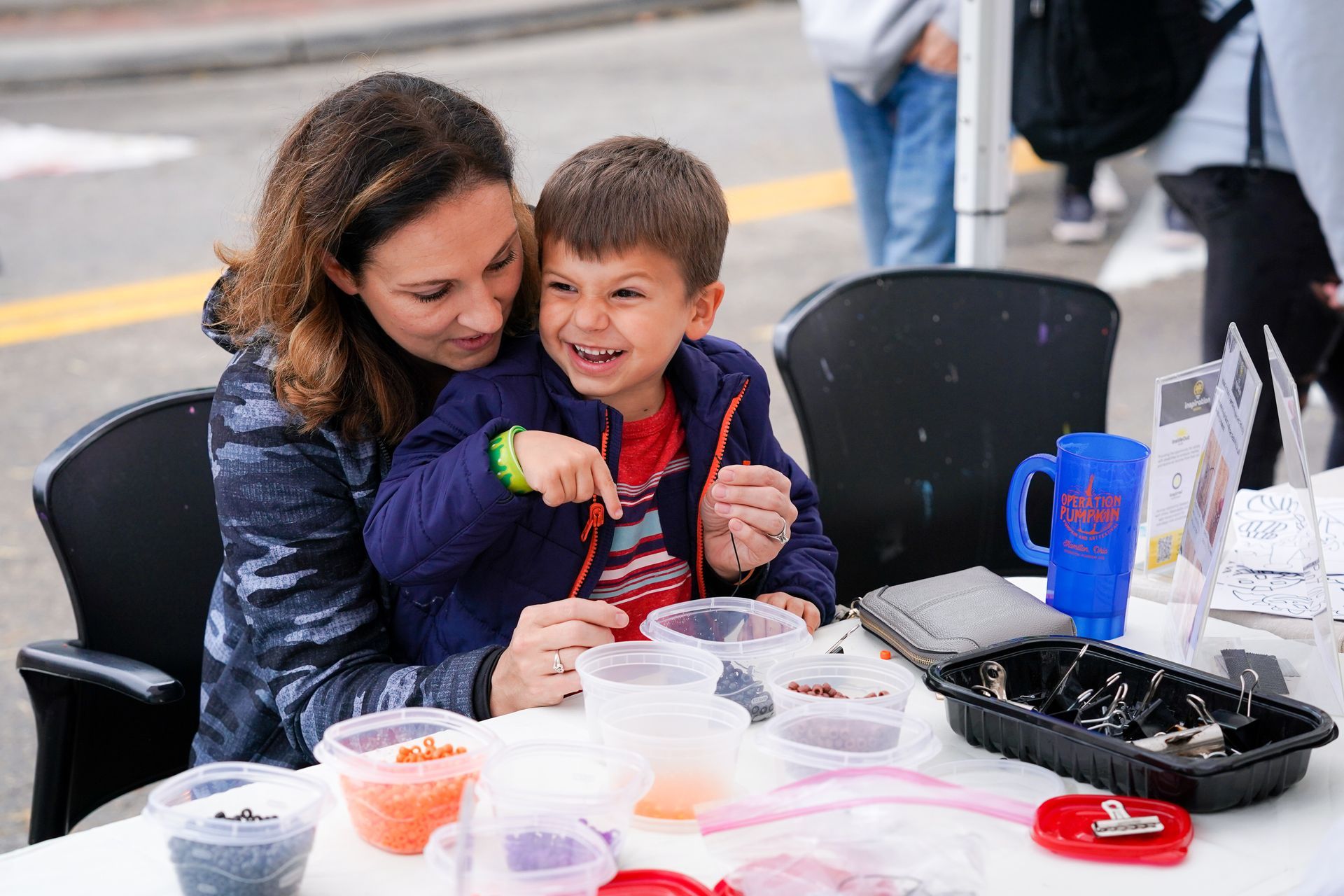 a woman is sitting next to a young boy at a table