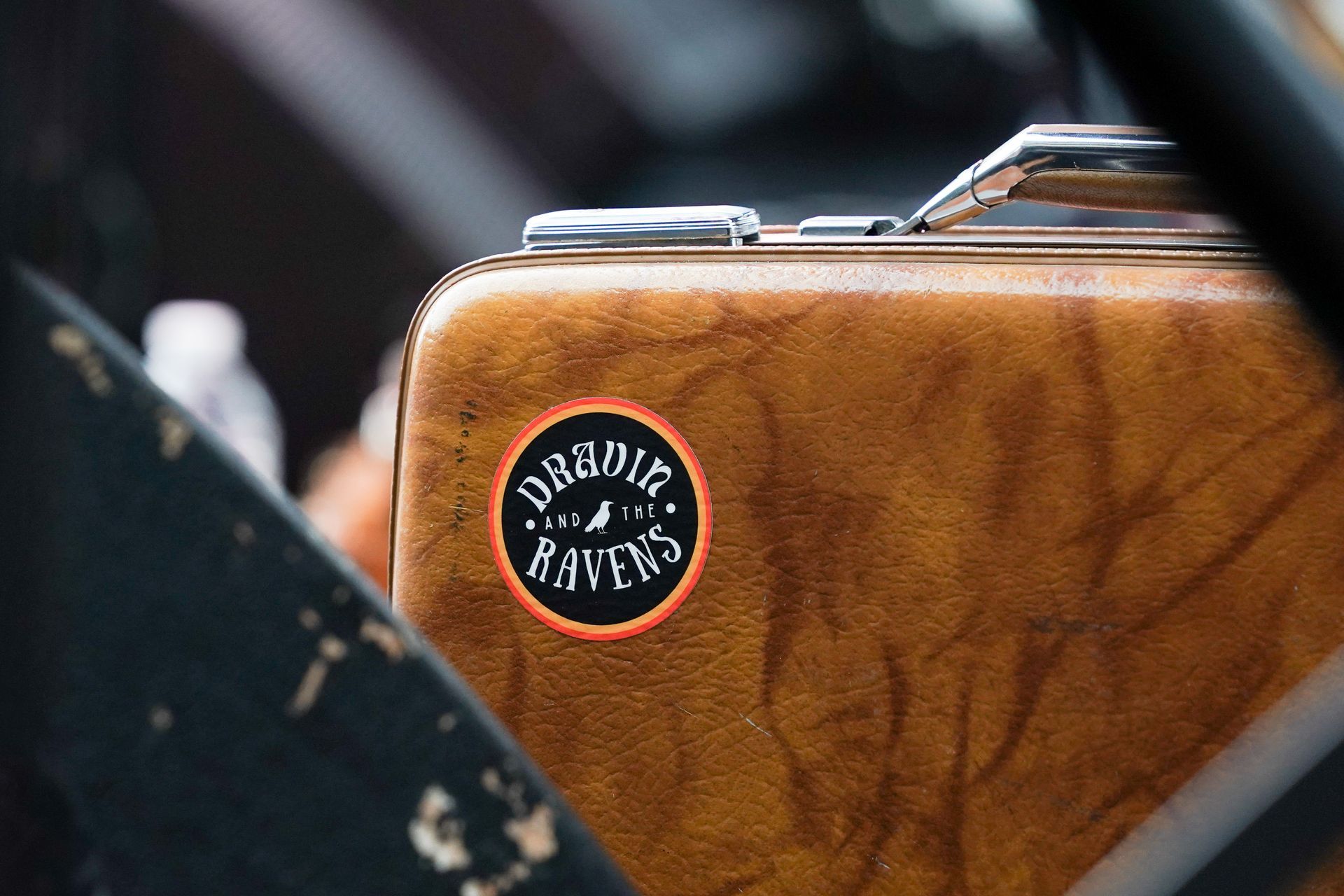 a brown suitcase with a sticker on it that says urban rovers