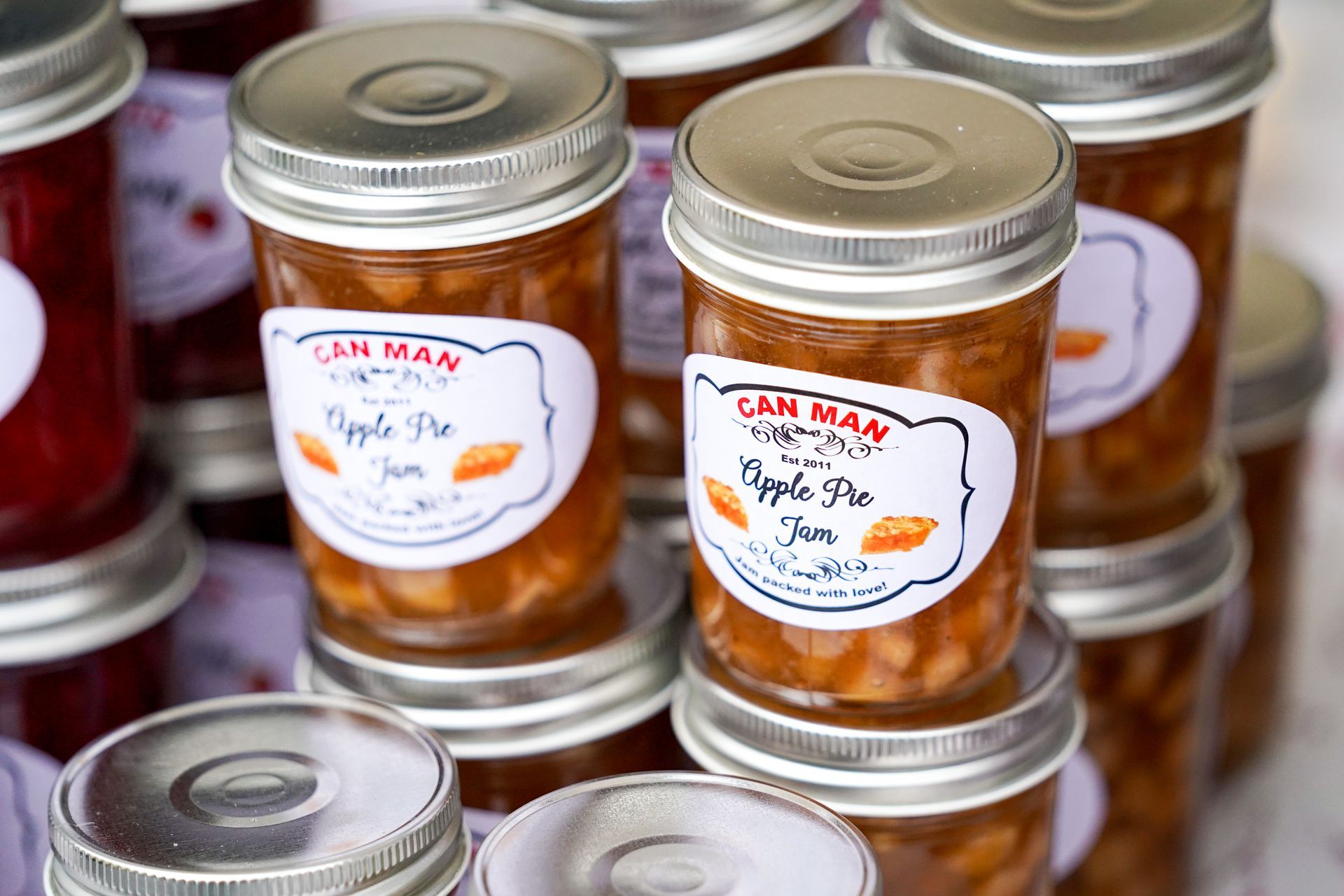 a bunch of jars of apple pie jam are stacked on top of each other