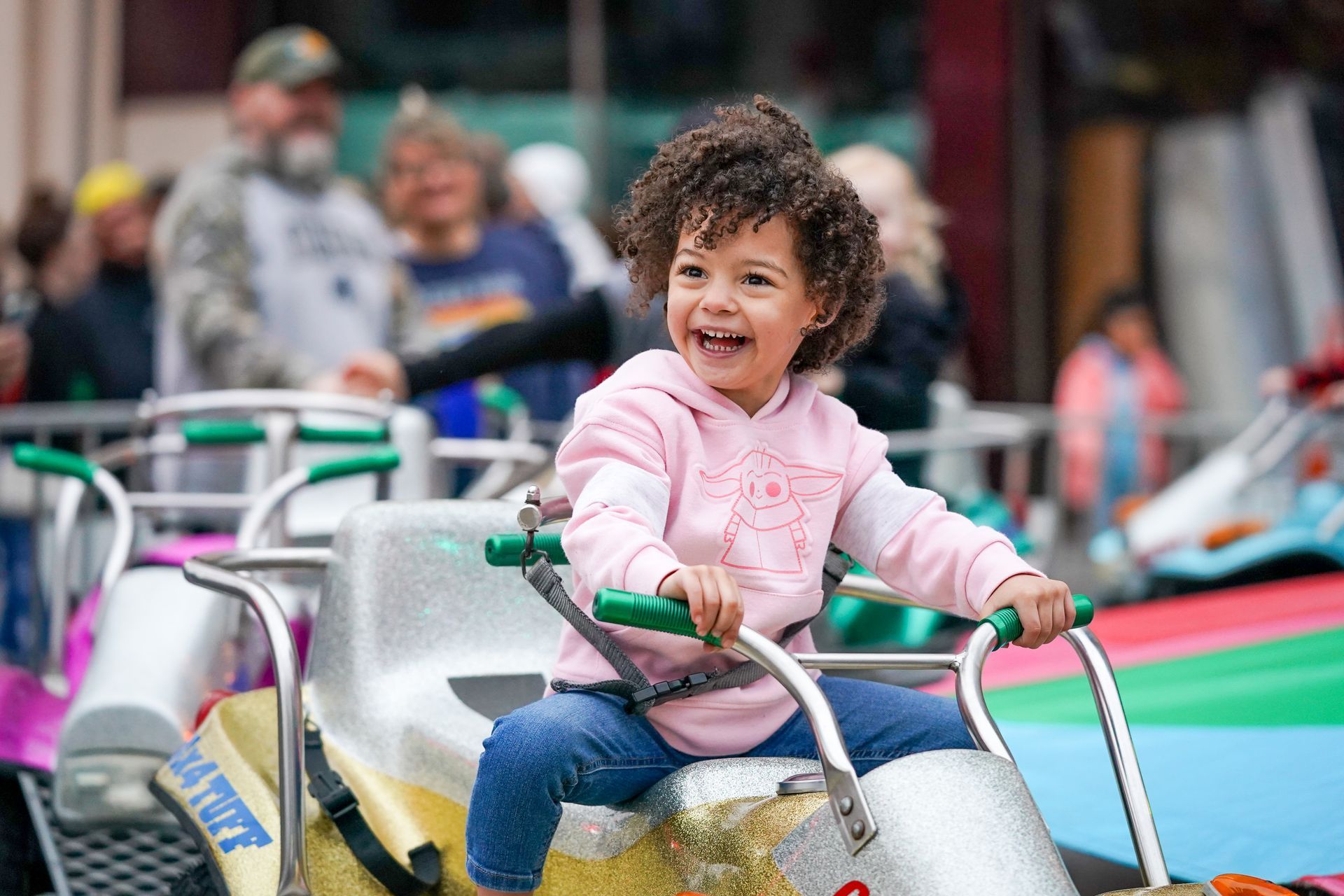 kid with pink shirt riding a bicycle