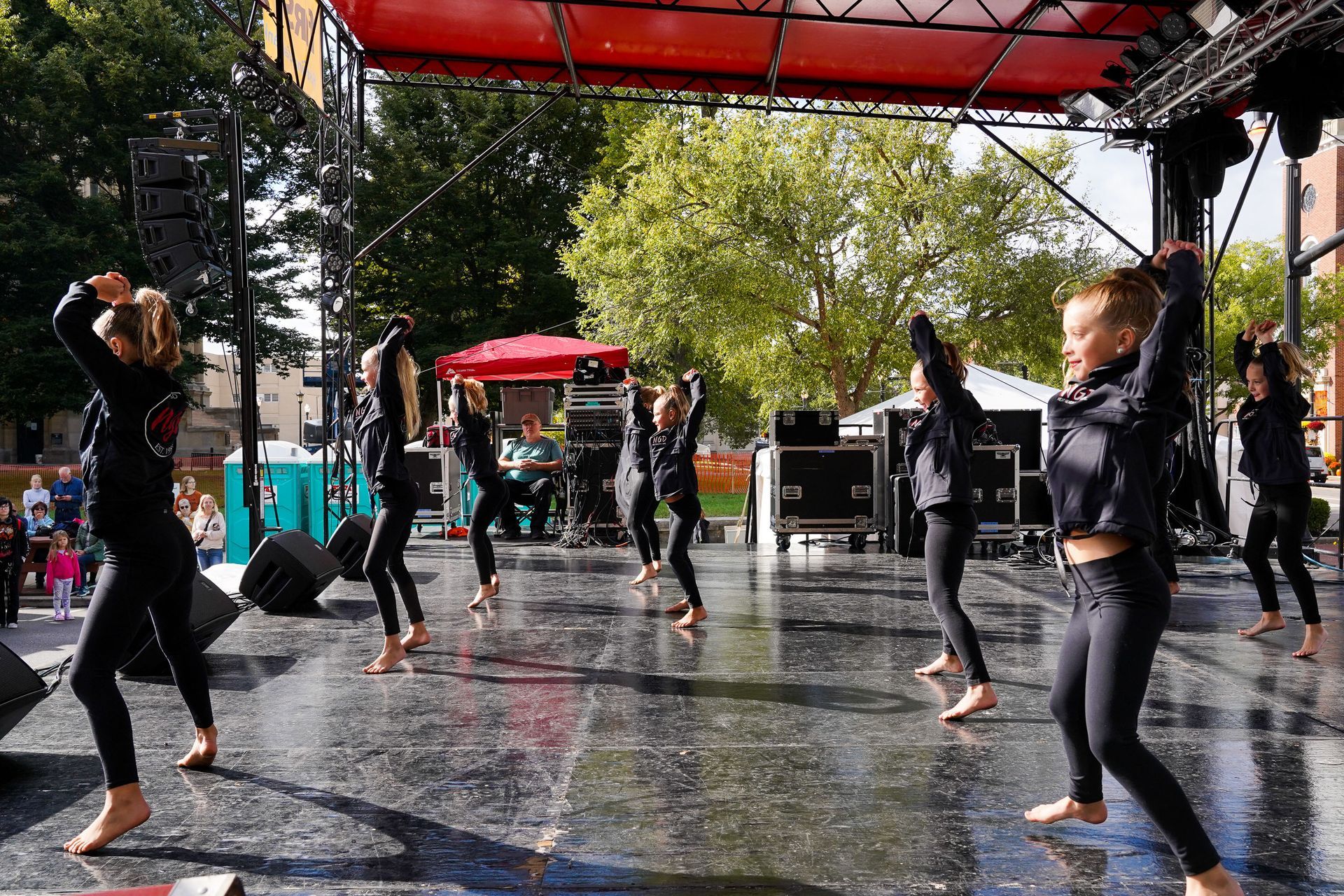 a group of young girls are dancing on a wet stage