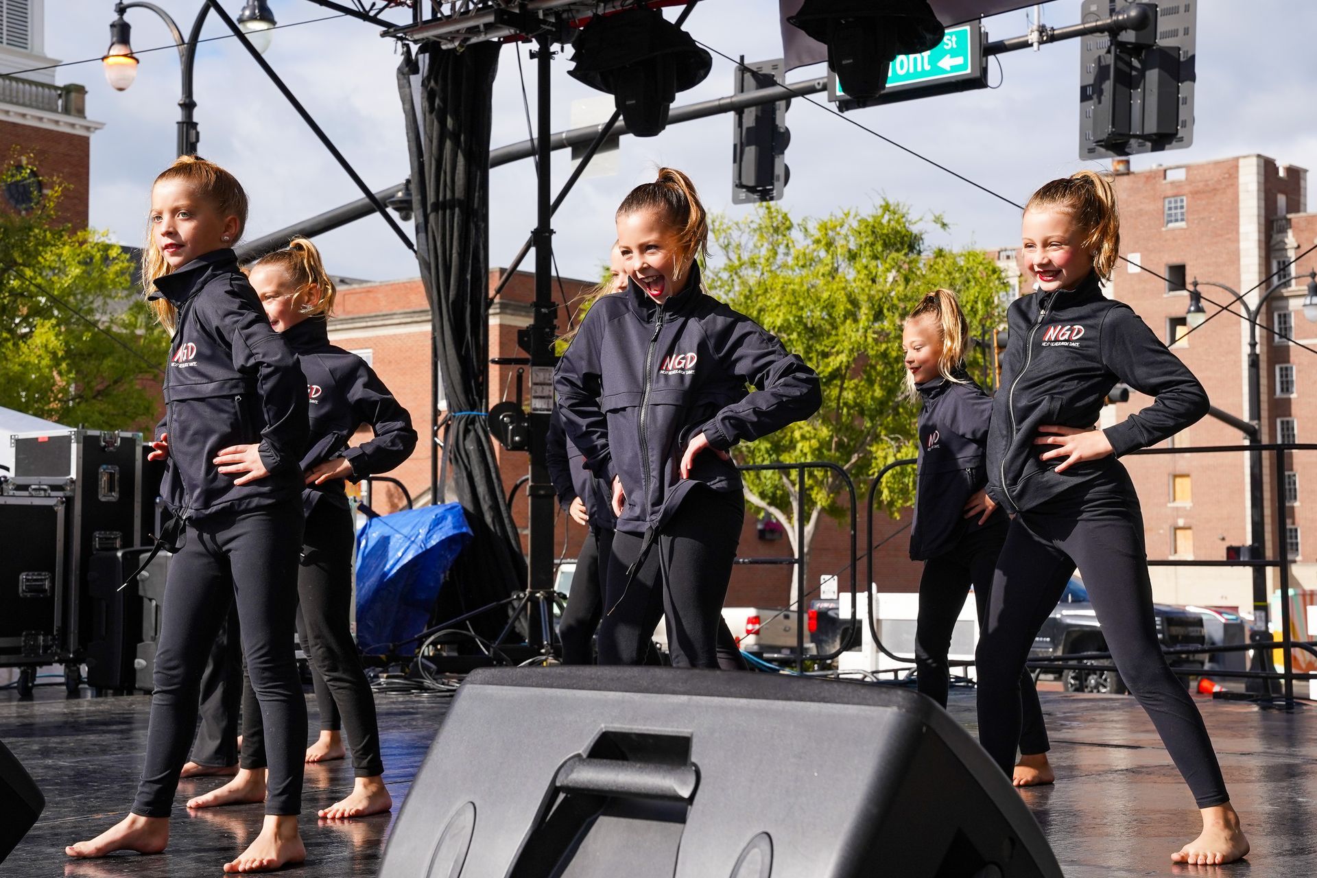 a group of young girls are dancing on a stage