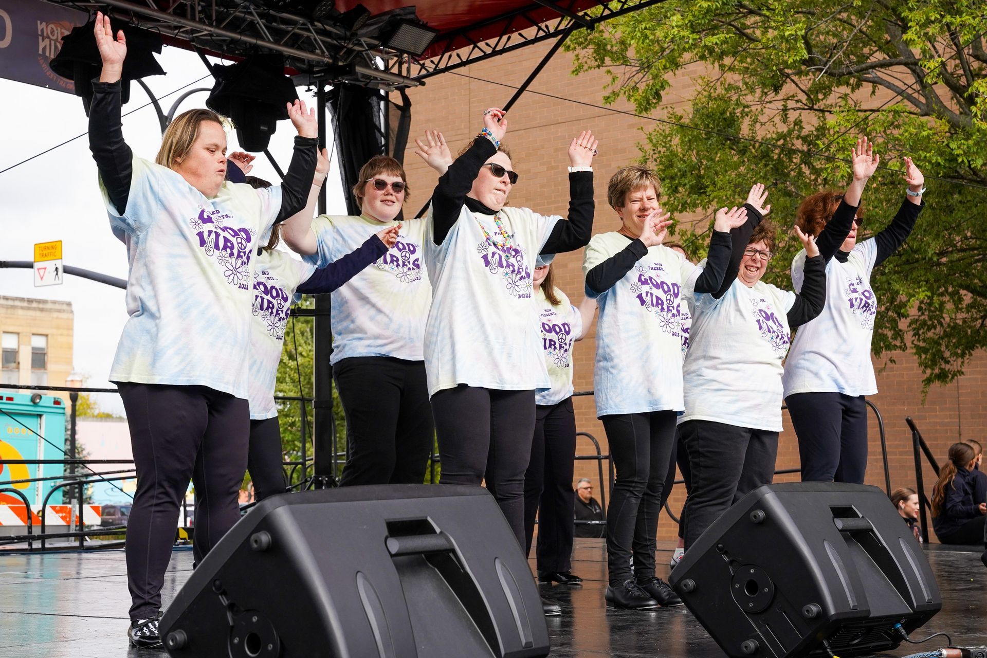 a group of women are standing on a stage with their hands in the air