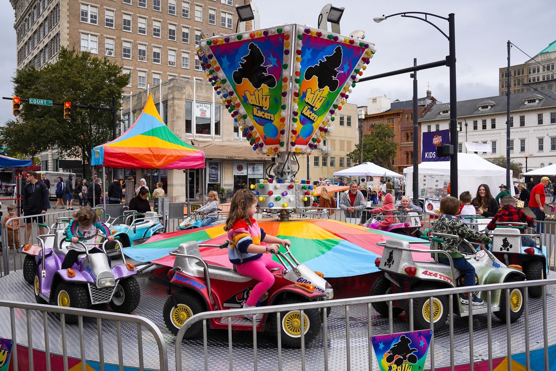 a girl is riding a four wheeler at a carnival